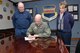 Timothy Slobodnik (L), 55th Civil Engineer Squadron and AFGE Local Chapter 1486 president and Shay Caris (R), 55th FSS Civilian Personnel Flight Labor Relations officer watch Col. Michael Manion, 55th Wing commander, sign a new collective bargaining agreement on March 7 at 55th Wing headquarters on Offutt Air Force Base, Nebraska.