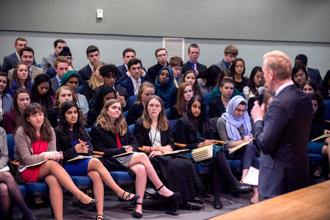 The deputy defense secretary speaks to an auditorium with high school students.