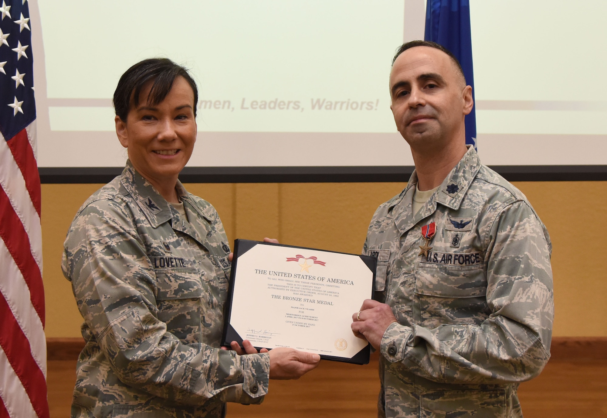 Col. Debra Lovette, 81st Training Wing commander, presents Maj. Jack Vilardi, 81st Medical Support Squadron TRICARE Operations and Patient Administration flight commander, with a certificate of recognition during a commander’s all-call at the Bay Breeze Event Center March 5, 2018, on Keesler Air Force Base, Mississippi. Vilardi was presented with a Bronze Star for meritorious achievement while assigned to a surgical team deployed to Iraq, April 2017, through Oct. 2017. (U.S. Air Force photo by Kemberly Groue)