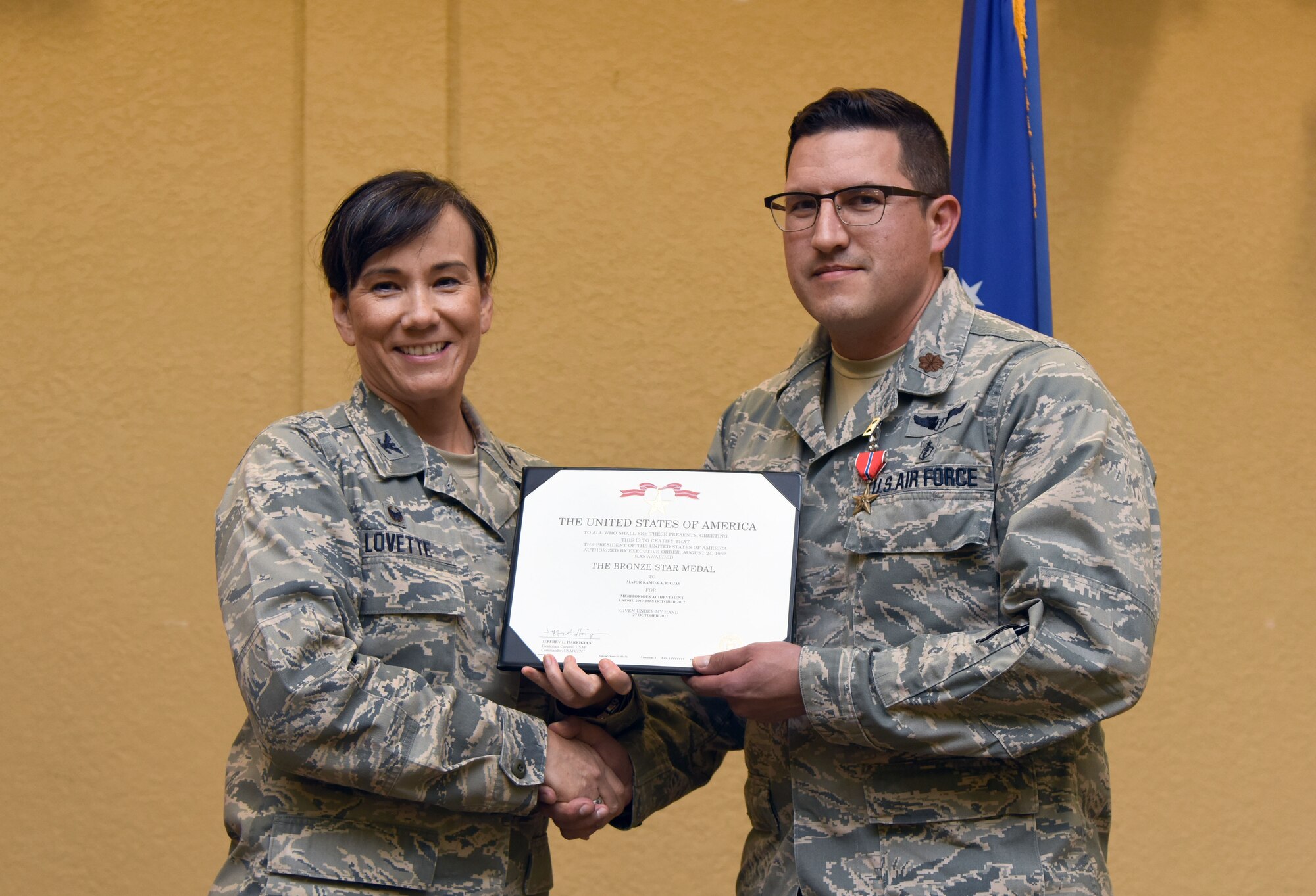 Col. Debra Lovette, 81st Training Wing commander, presents Maj. Ramon Riojas, 81st Surgical Operations Squadron general surgeon, with a certificate of recognition during a commander’s all-call at the Bay Breeze Event Center March 5, 2018, on Keesler Air Force Base, Mississippi. Riojas was presented with a Bronze Star for meritorious achievement while assigned to a surgical team deployed to Iraq, April 2017, through Oct. 2017. (U.S. Air Force photo by Kemberly Groue)