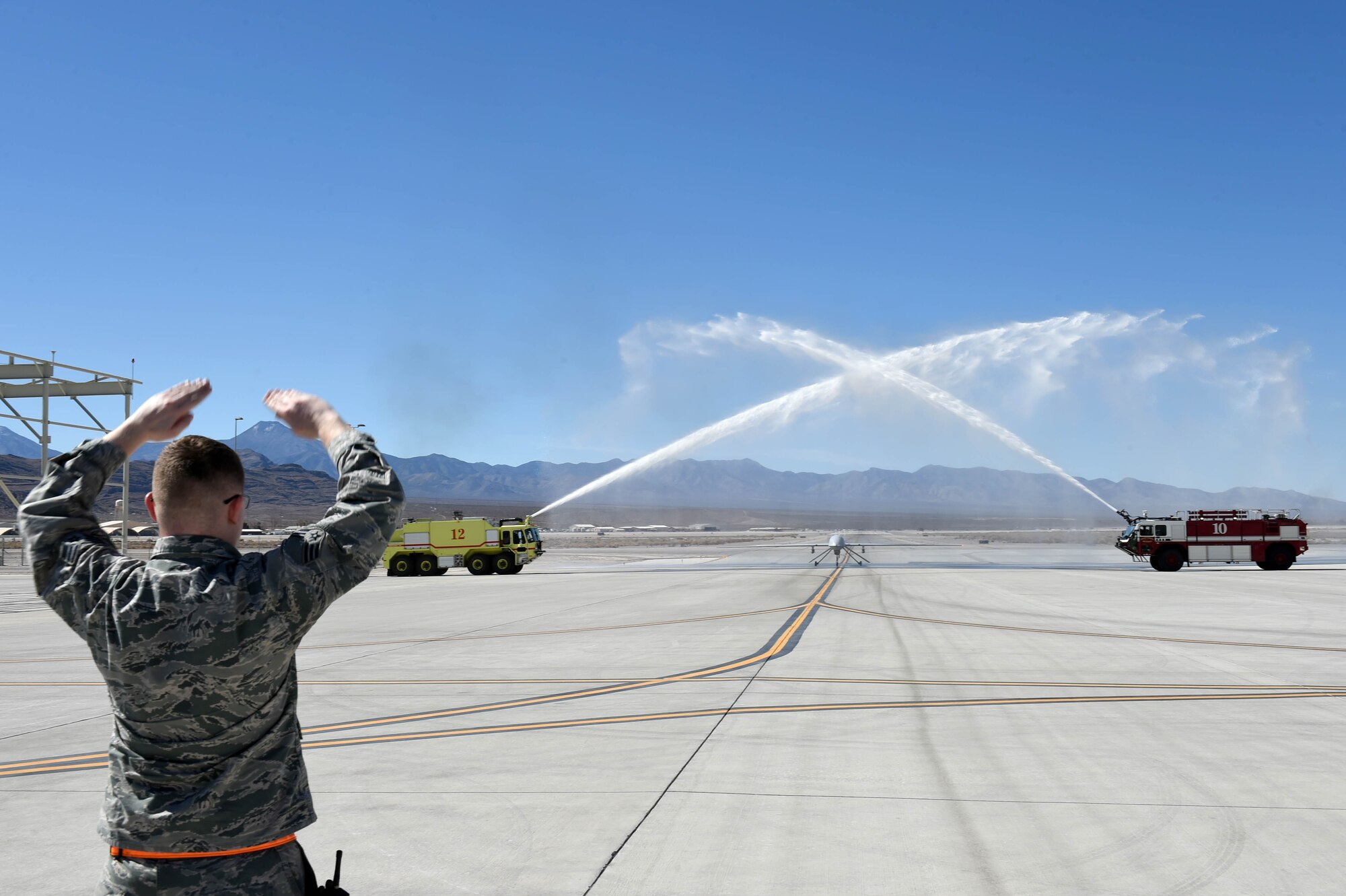 An MQ-1 Predator receives a water salute to commemorate its time in service and capabilities provided to combatant commanders and troops on the ground March 9, 2018, at Creech Air Force Base, Nev. Airmen have operated the MQ-1 for more than 20 years and provided intelligence, surveillance, reconnaissance and strike capabilities to the fight 24/7/365 across multiple areas of responsibilities. (U.S. Air Force photo by Senior Airman James Thompson)