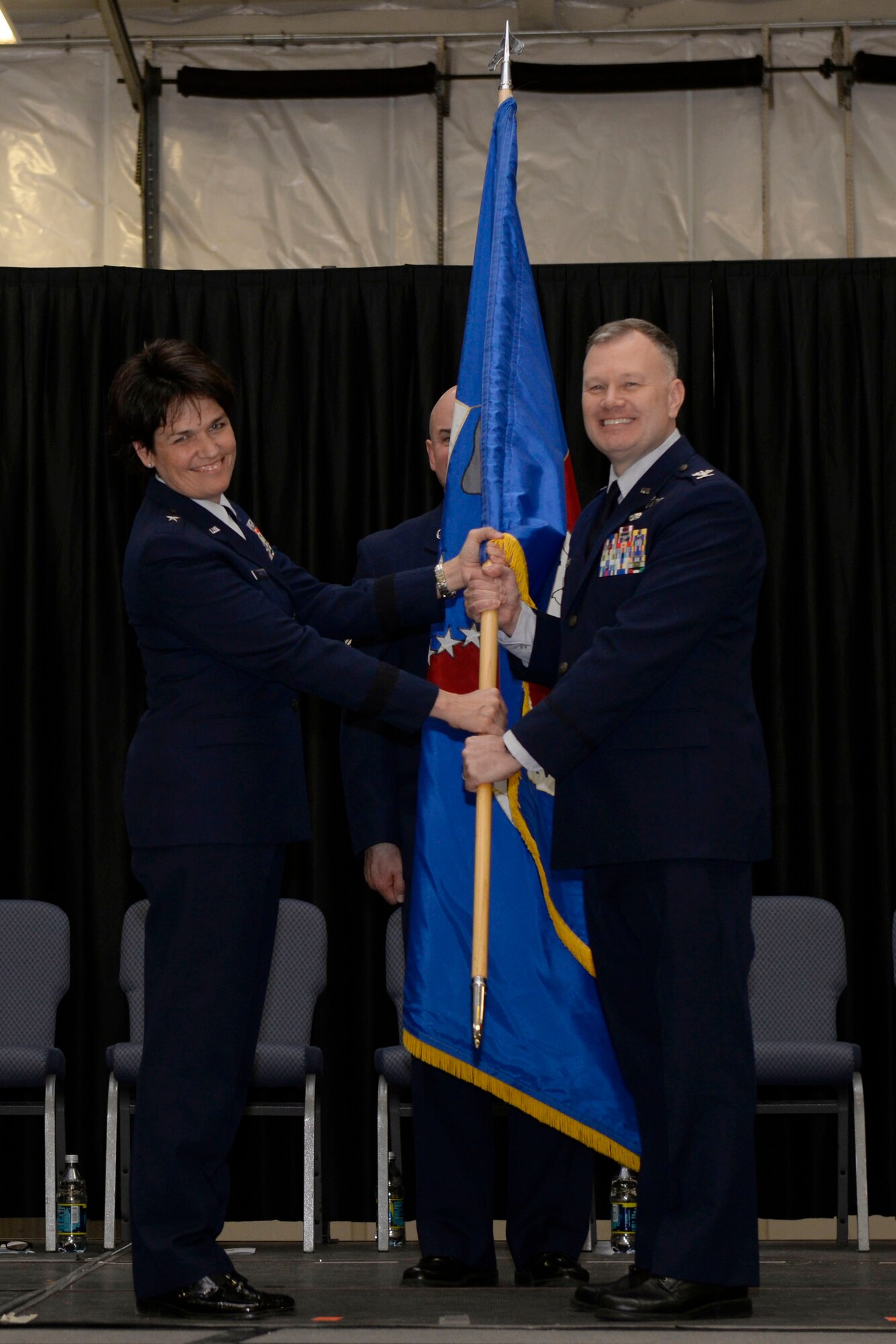 Col. John W. Pogorek (right) accepts the 157th Air Refueling Wing guidon from Brig. Gen. Laurie M. Farris during a change of command ceremony at Pease Air National Guard Base, N.H., March 10, 2018. The change of commmand cermony represents a formal transfer of authority and responsibility from an outgoing commander to the incoming commander.(N.H. Air National Guard photo by Senior Airman Taylor Queen)