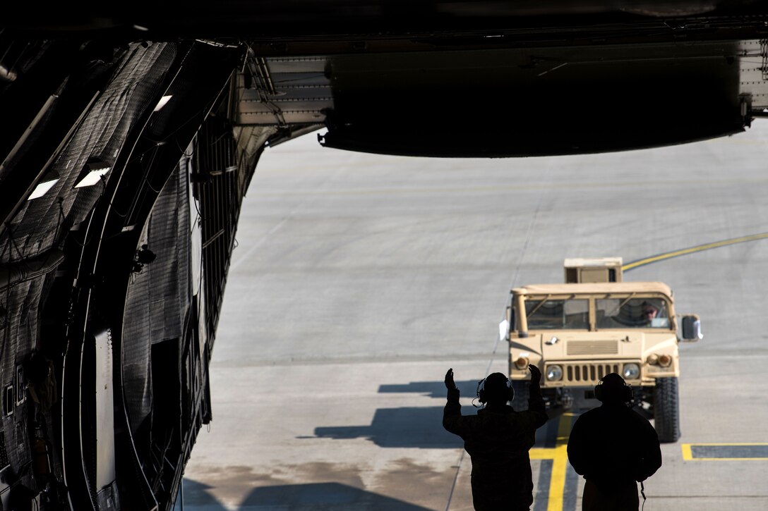 Airmen guide a Humvee onto a C-5M Super Galaxy.