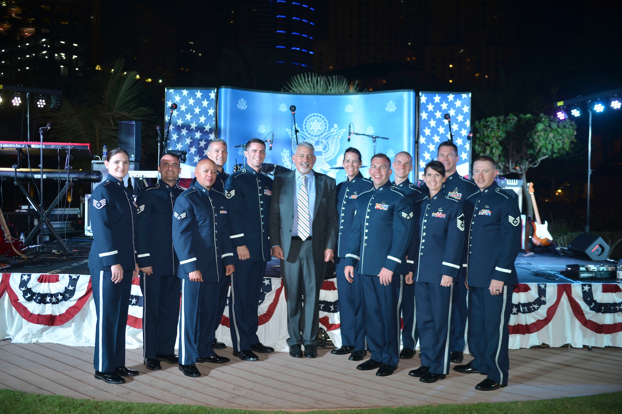 U.S. Air Forces Central Command band poses with Paul R. Malik, U.S. Consul General during the U.S. National Day celebration March 7, 2018 at the Ritz-Carlton Hotel and Resort, Dubai. The AFCENT band is a popular music ensemble comprised of American Airman who are charged with using music to bring diverse peoples from different cultures together to engender mutual appreciation and respect.(U.S. Air Force Photo by Tech Sgt. Anthony Nelson Jr. )