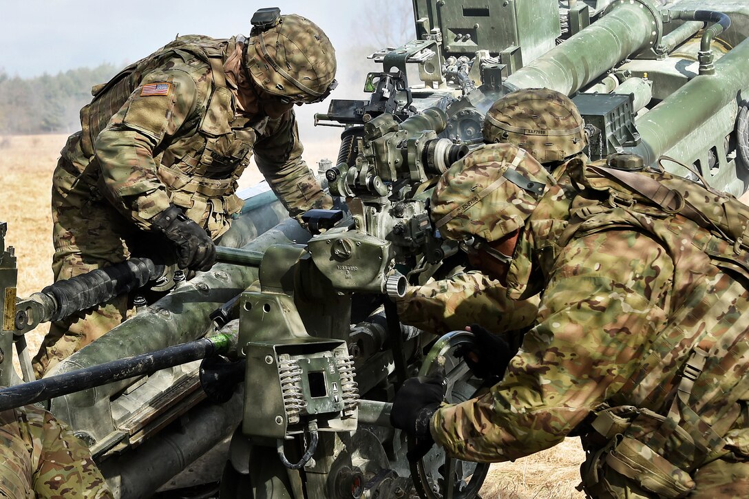 Soldiers prepare a M777 howitzer to be fired.