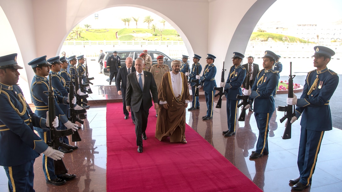 Defense Secretary James N. Mattis walks with the Omani Defense Affairs Minister on a red carpet.