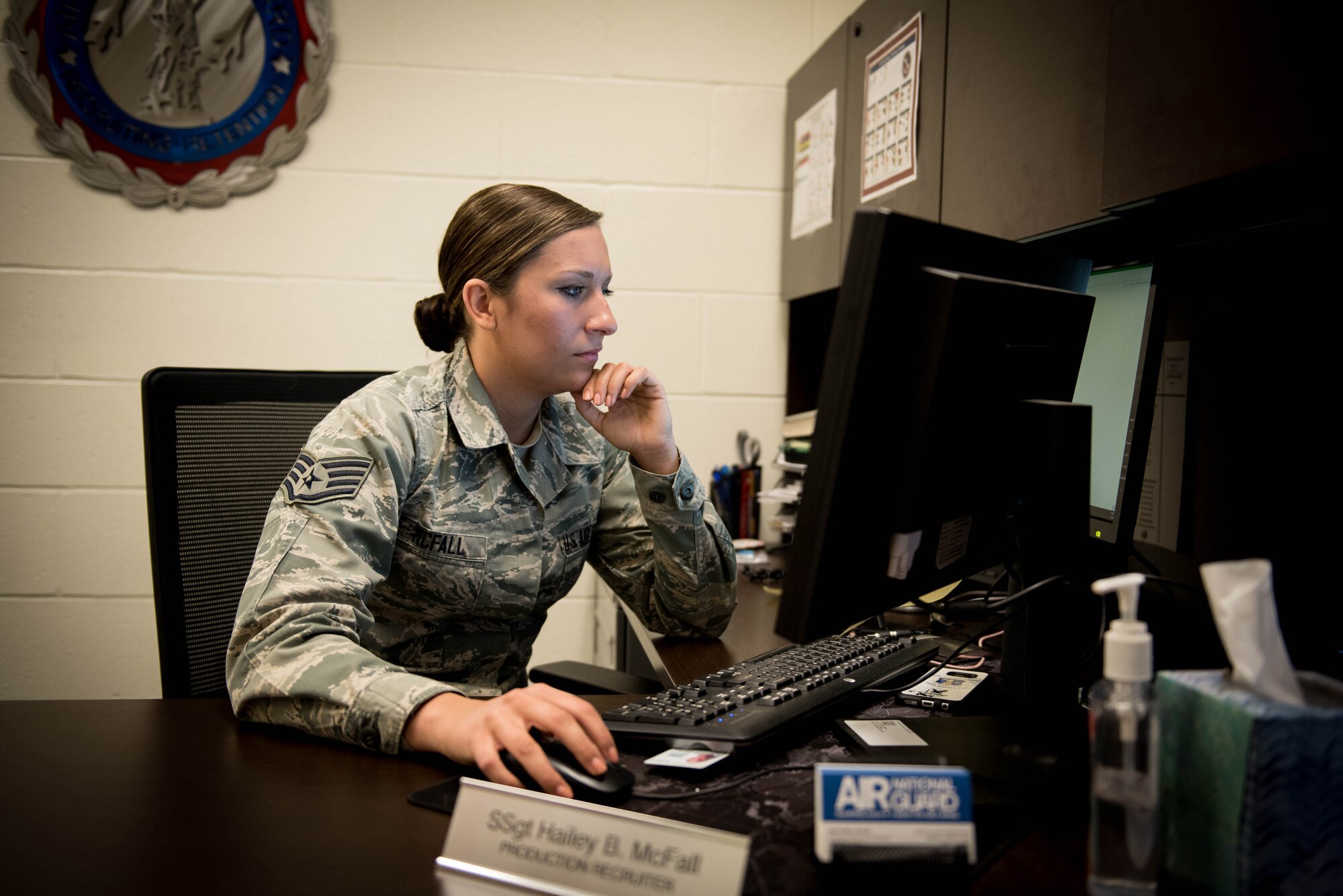 Sergeant McFall looking at her computer monitor at her desk at work.