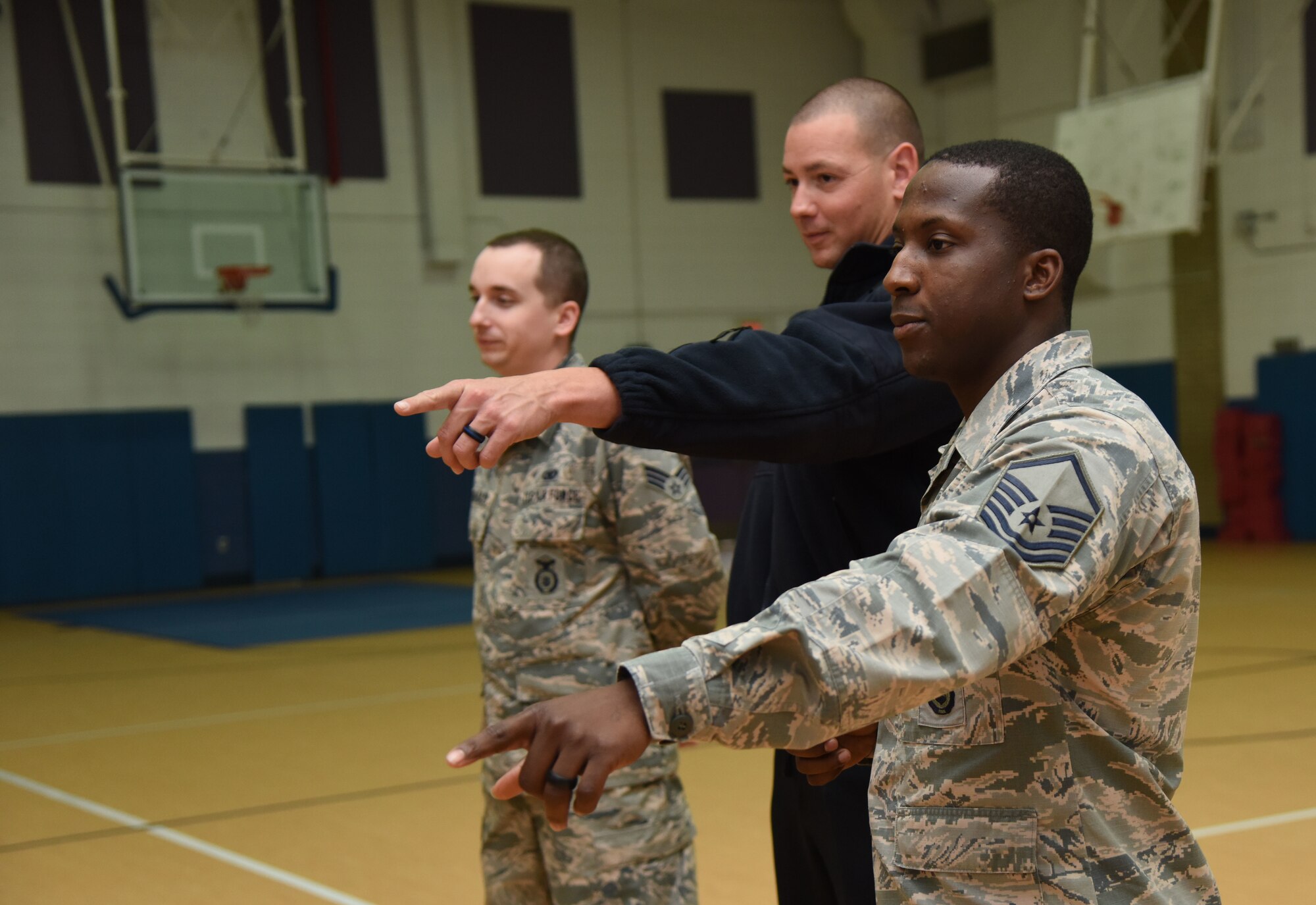 Senior Airman 81st Security Forces Squadron training instructor, Justin Depew, 81st SFS patrolman, and Master Sgt. Cordarius Lewis, 81st SFS operations NCO in charge, discuss safety procedures during lockdown training at the Keesler Youth Center March 8, 2018, on Keesler Air Force Base, Mississippi. In lieu of recent active shooter incidents in schools, defenders conducted the training to discuss school safety during a potential active shooter situation. (U.S. Air Force photo by Kemberly Groue)