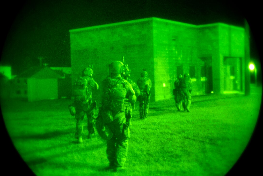 Special Operation soldiers advance toward a building.