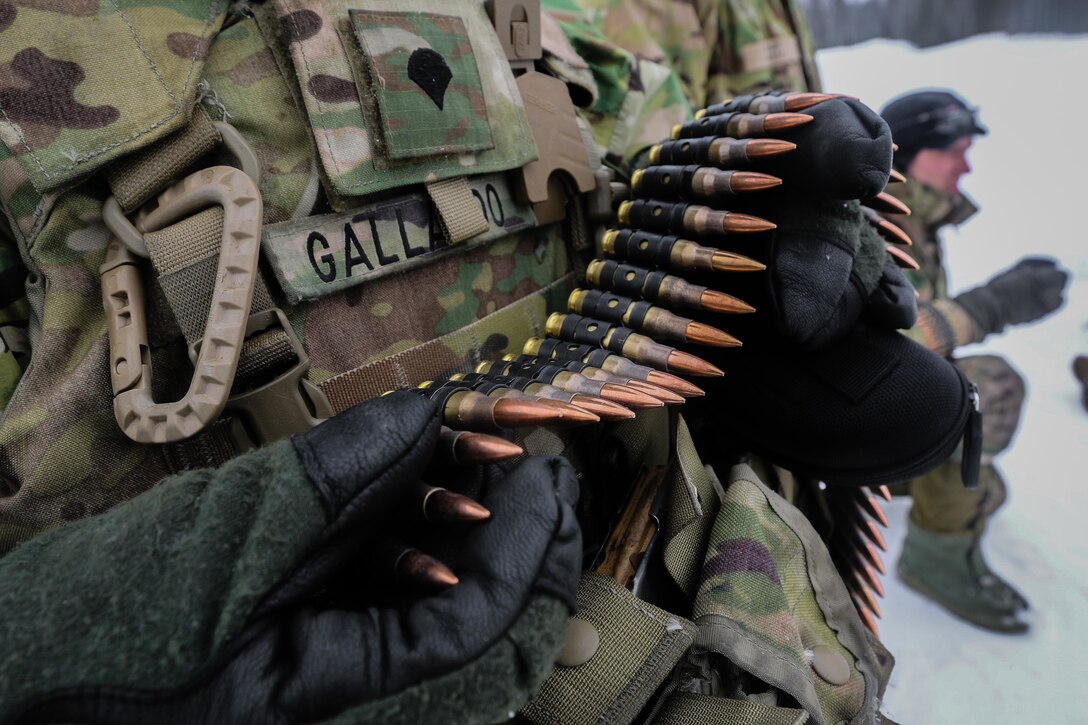 A soldier collects ammunition during multinational weapons training