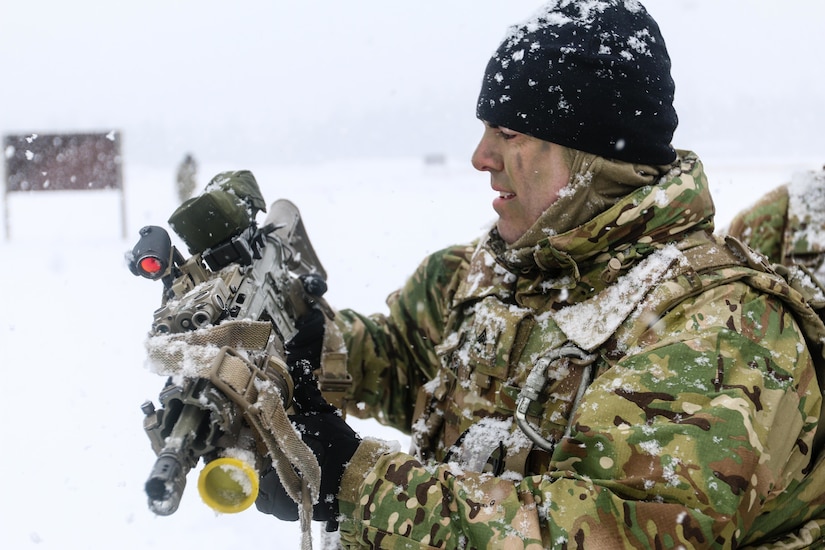 A Danish soldiers exams his weapon during the multinational training exercise