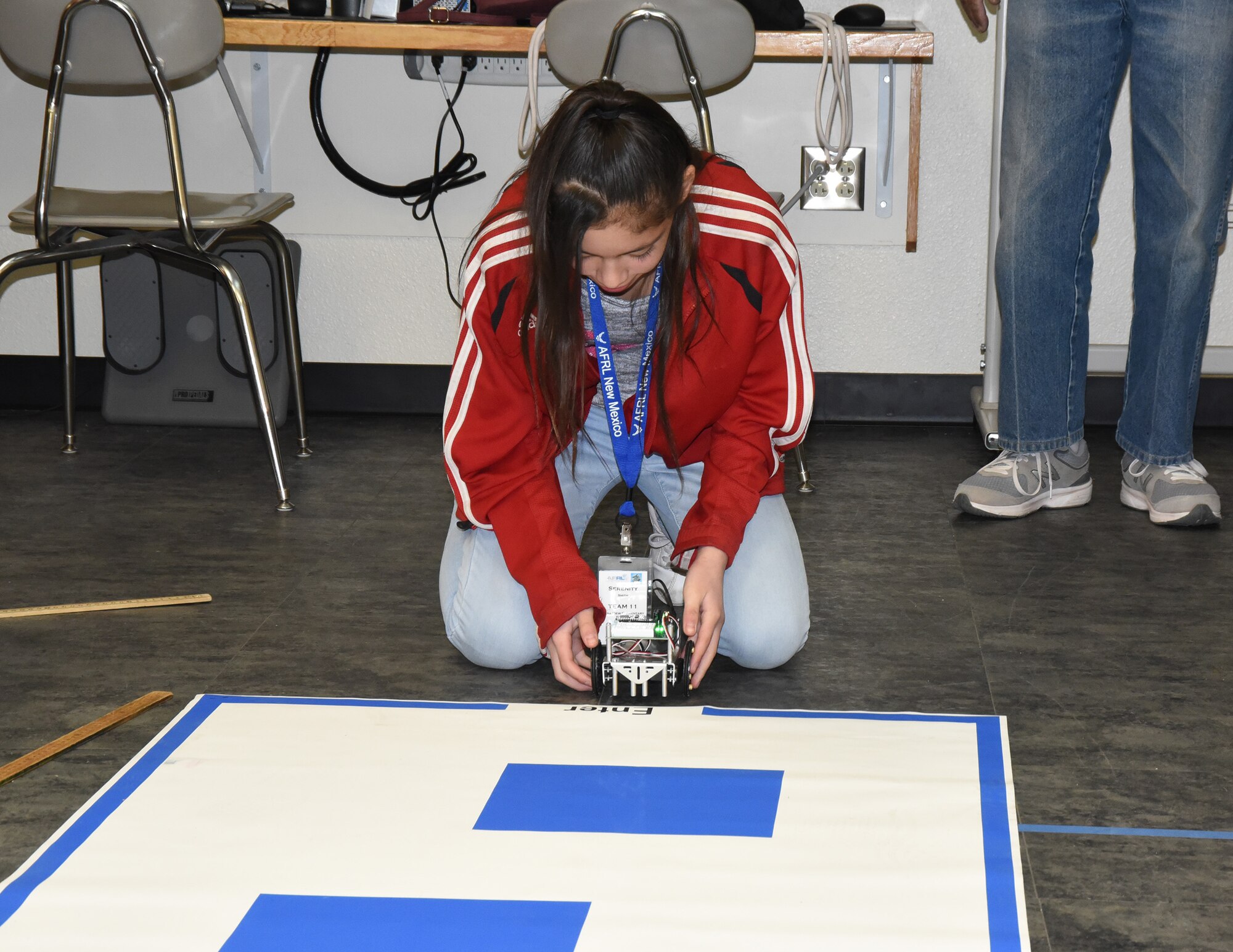 After programming her robot, Serenity Smith, a sixth grader from Mesa View Elementary School, tests it on a simple maze at the Air Force Research Laboratory's La Luz Academy Robotic Challenge Expo March 9 at Kirtland. Smith was one of more than 100 students from around the state that competed at the event.