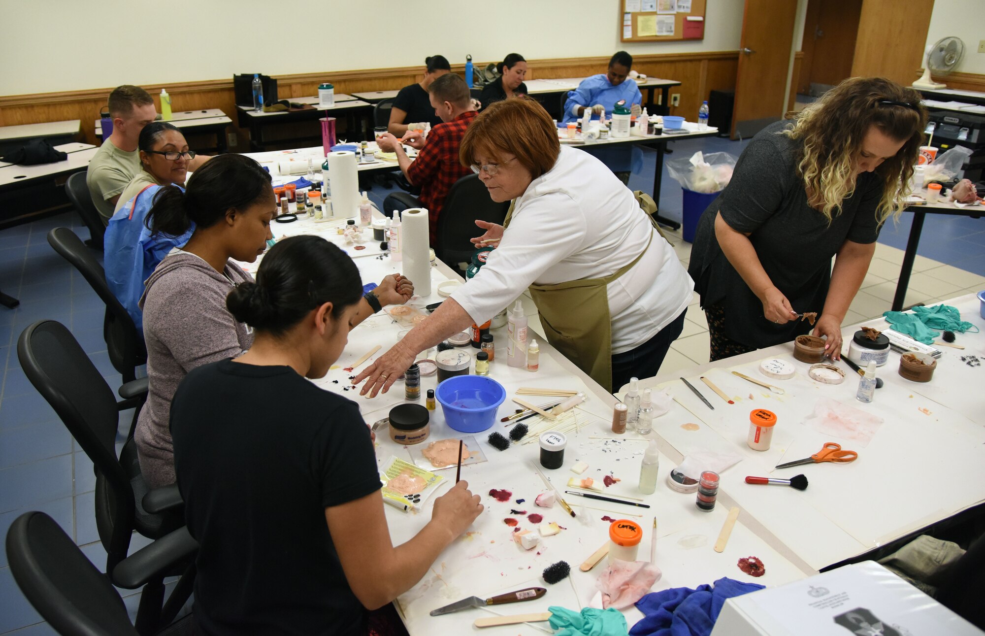 Volunteers learn how to apply moulage during a training session at Allee Hall March 8, 2018, on Keesler Air Force Base, Mississippi. The session was held to teach volunteers how to apply moulage on exercise “casualties” to provide emergency responders with a more realistic training experience. (U.S. Air Force photo by Kemberly Groue)