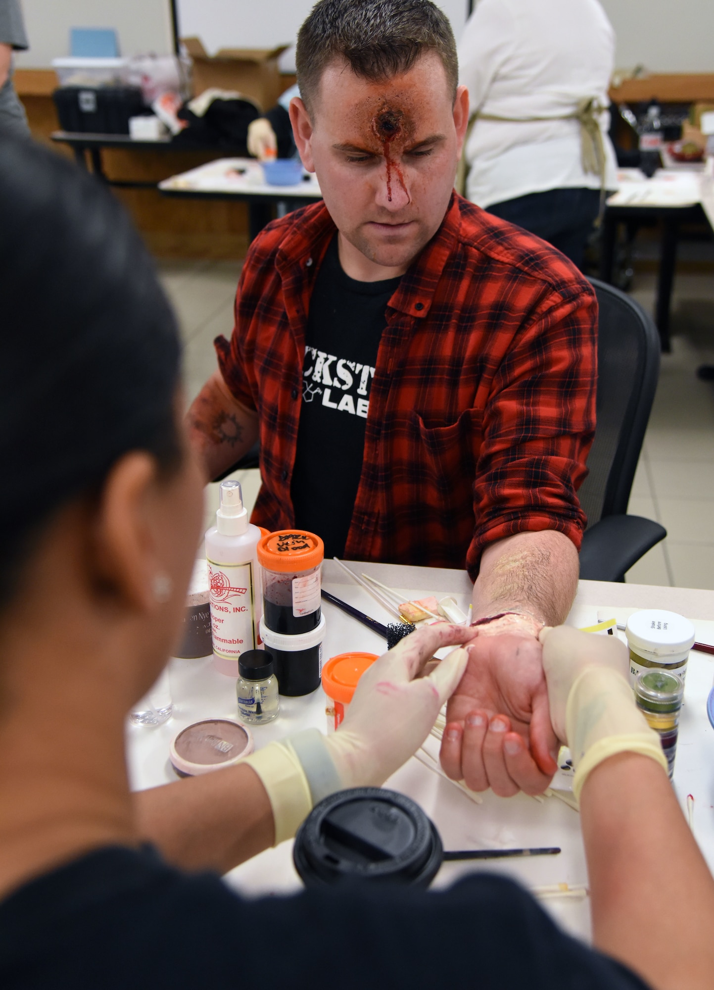 Staff Sgt. Dominque Mason, 81st Medical Operations Squadron neurodiagnostic technologist, applies moulage to Staff Sgt. Matthew Clinesmight, 81st Security Forces Squadron evaluator, during a training session at Allee Hall March 8, 2018, on Keesler Air Force Base, Mississippi. The session was held to teach volunteers how to apply moulage on exercise “casualties” to provide emergency responders with a more realistic training experience. (U.S. Air Force photo by Kemberly Groue)