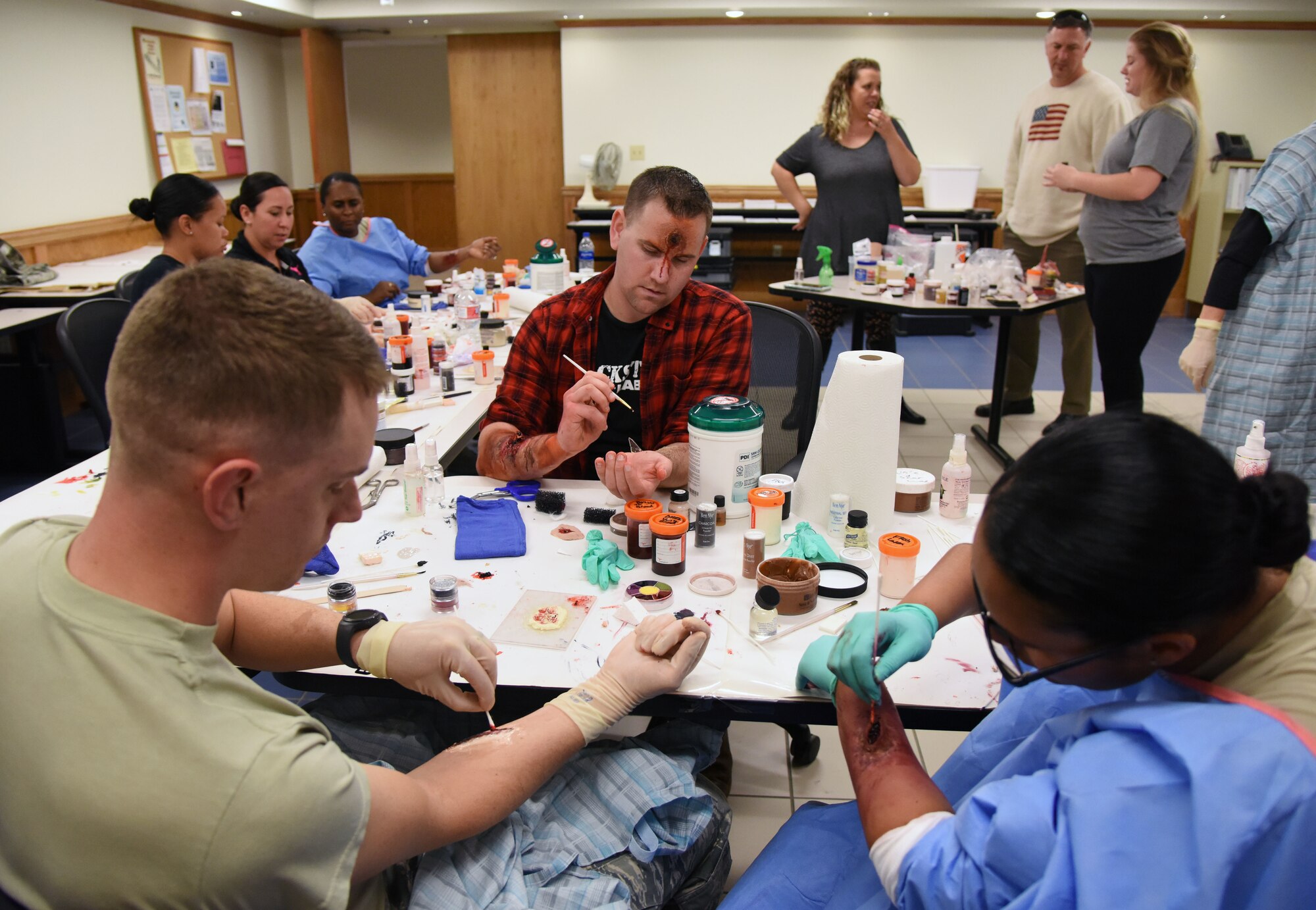 Volunteers learn how to apply moulage during a training session at Allee Hall March 8, 2018, on Keesler Air Force Base, Mississippi. The session was held to teach volunteers how to apply moulage on exercise “casualties” to provide emergency responders with a more realistic training experience. (U.S. Air Force photo by Kemberly Groue)