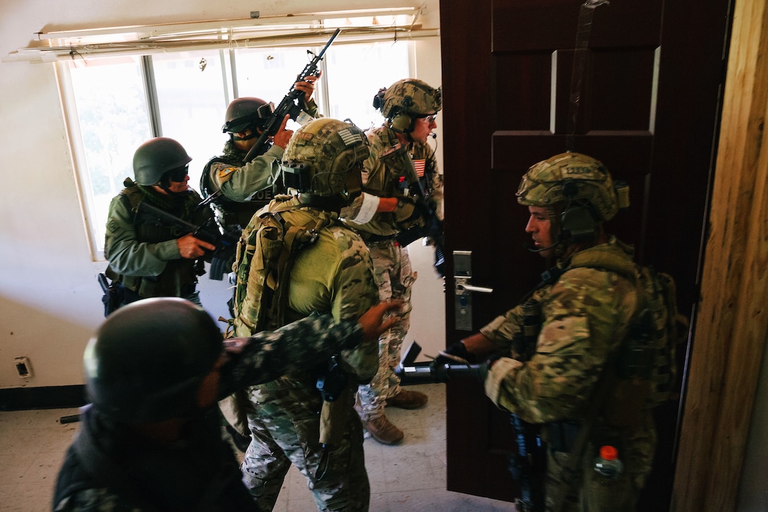 Special Forces soldiers rush into a room.