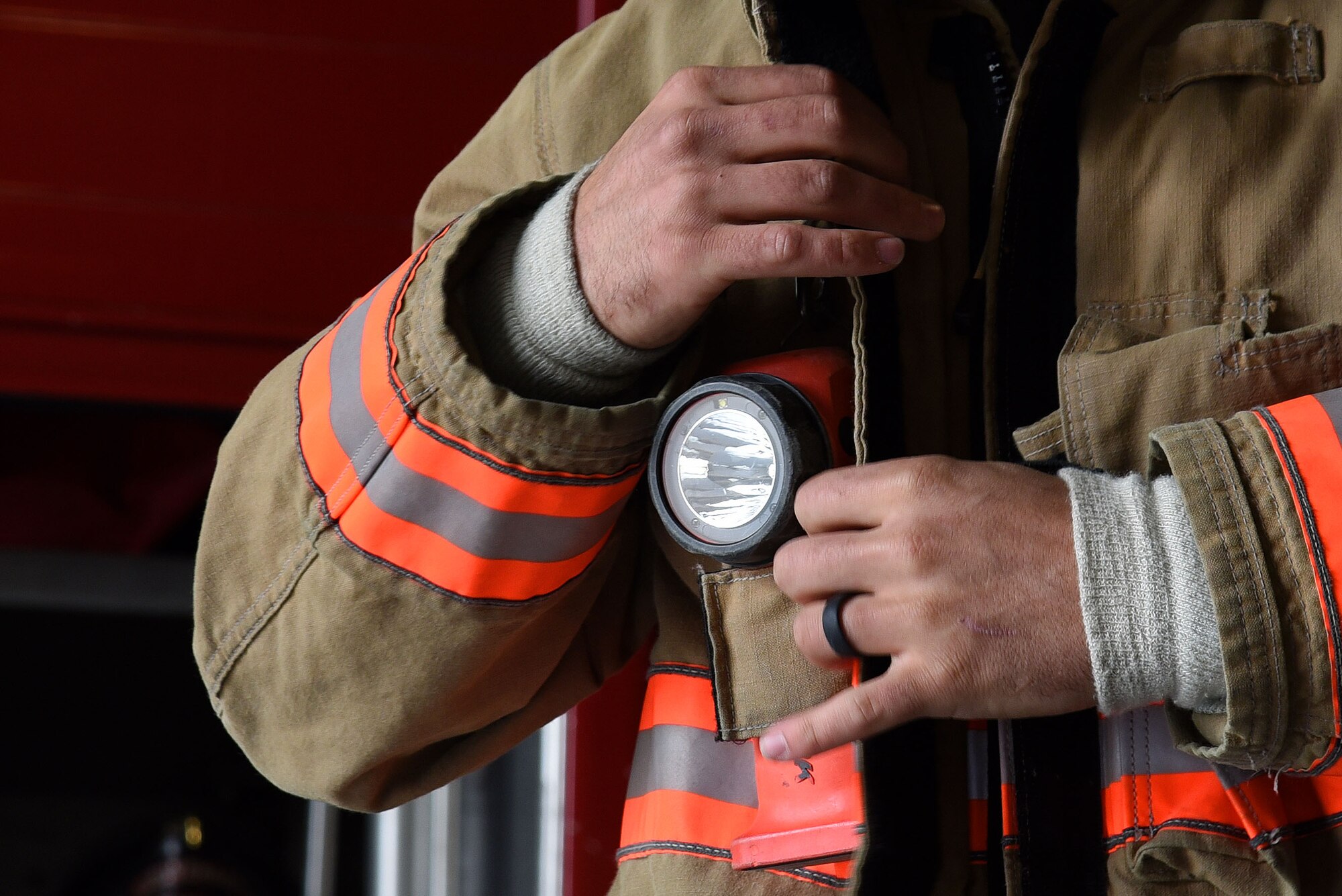 U.S. Air Force Airman 1st Class Trevor Britt, 20th Civil Engineer Squadron firefighter, secures his coat during a competition with a coworker at Shaw Air Force Base, S.C., March 8, 2018.