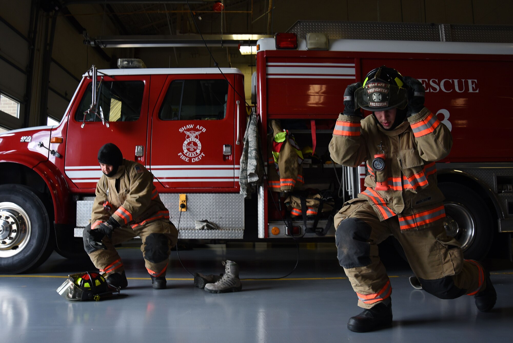 U.S. Air Force Airmen 1st Class Nicholas Denning, left, and Trevor Britt, 20th Civil Engineer Squadron firefighters, don their gear during a competition demonstrating their proficiency at Shaw Air Force Base, S.C., March 8, 2018.