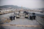 180312-N-DX072-050 SASEBO, Japan (March 12, 2018) Sailors standby at their stations on the forecastle as the amphibious transport dock ship USS Green Bay (LPD 20) is tugged away from the pier. Green Bay is operating in the Indo-Pacific region to enhance interoperability with partners and serve as a ready-response force for any type of contingency. (U.S. Navy photo by Mass Communication Specialist 2nd Class Anaid Banuelos Rodriguez/Released)
