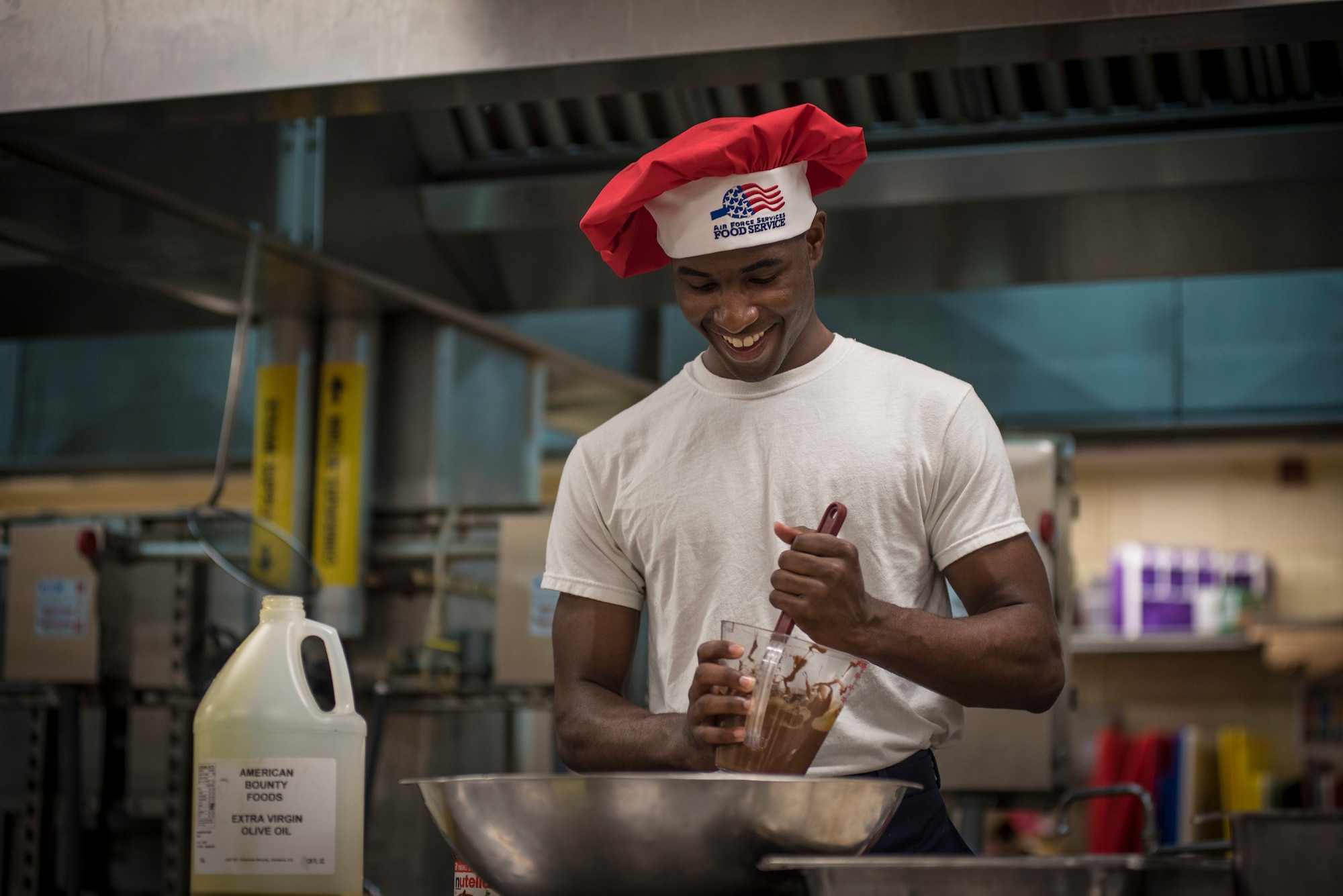 Airman 1st Class Tyrell Jackson stirs nougat creme during a Top Chef competition March 8, 2018, at Magellan Inn Dining Facility, Andersen Air Force Base, Guam. Jackson is a services apprentice and competed for the title of Top Chef of the Quarter by preparing a chicken parmesan dish. (U.S. Air Force photo by Staff Sgt. Alexander W. Riedel)