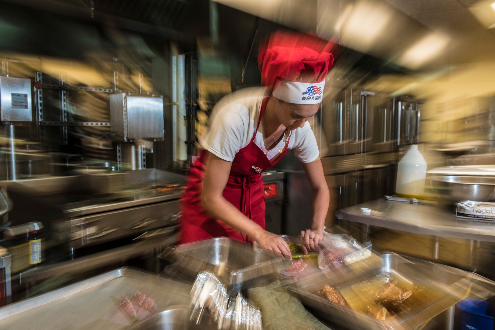 U.S. Air Force Senior Airman Caroline Spellen, 36th Force Support Squadron food services supervisor rushes to prepare a dish during a "Top Chef" competition March 8, 2018, at Magellan Inn Dining Facility, Guam. Spellen won the quarterly challenge, which tasked Air Force and Army cooks to serve a creative dish with mandatory ingredients provided in a "mystery box." (U.S. Air Force photo by Staff Sgt. Alexander W. Riedel)