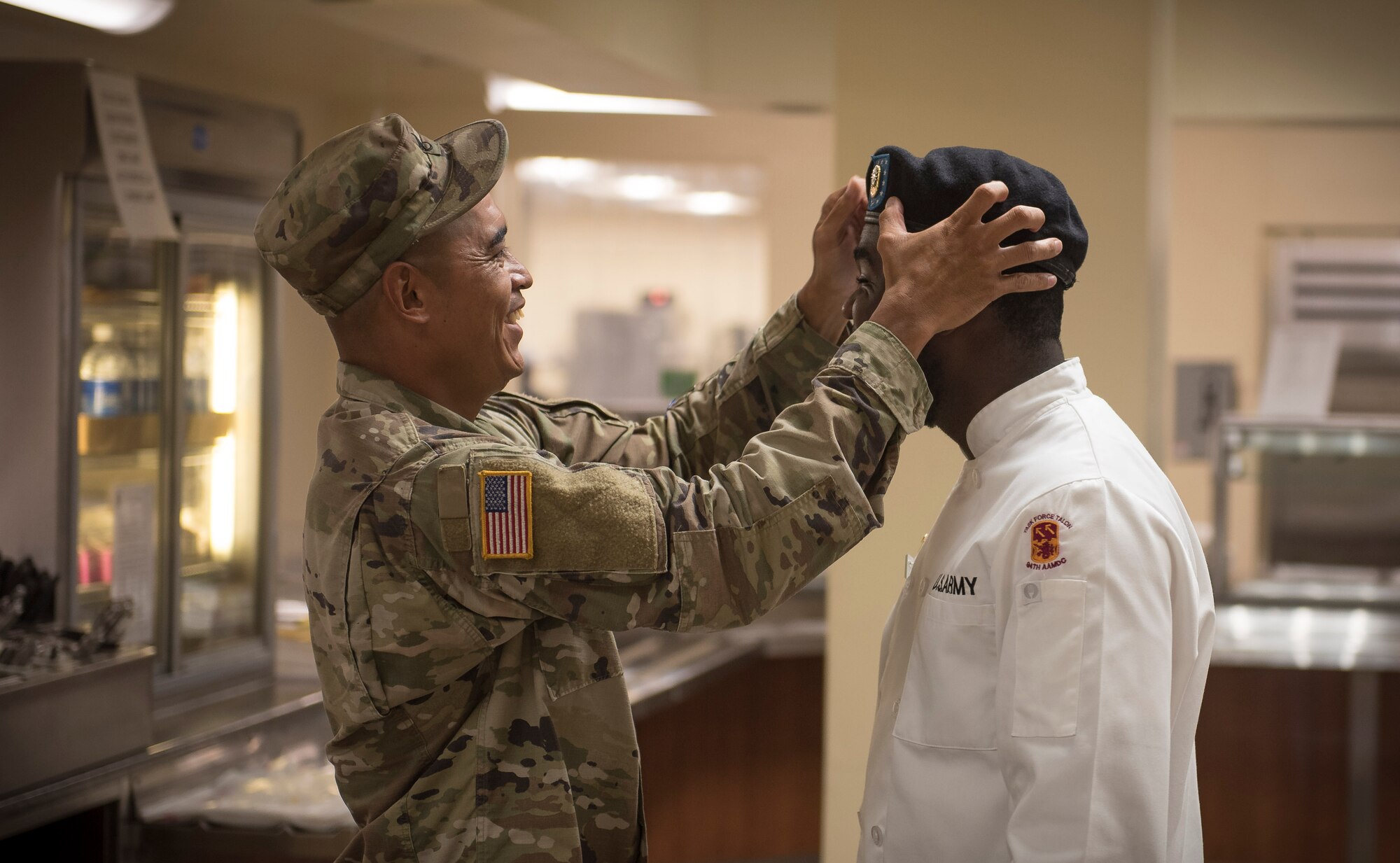 U.S. Army Staff Sgt. Clarence Borja, left, adjusts the beret for Specialist Kevron Usher before the Soldier presents his food creation in front of a panel of judges during the quarterly Top Chef competition March 8, 2018, at Magellan Inn Dining Facility, Guam. Borja is a culinary NCO and Usher is a culinary specialist, both assigned to Task Force Talon's  E Battery, 3rd Air Defense Artillery Regiment. Soldiers are regularly attached to the U.S. Air Force's 36th Force Support Squadron in support of operations at Andersen Air Force Base. (U.S. Air Force photo by Staff Sgt. Alexander W. Riedel)