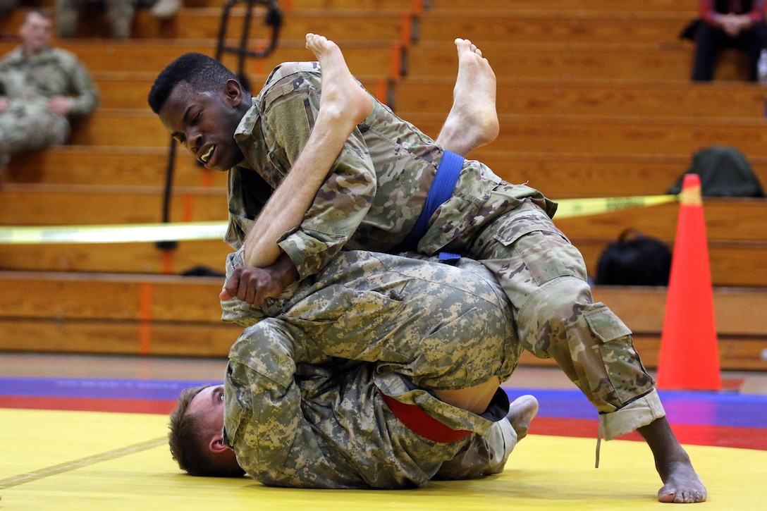 A soldier moves for a submission hold in his match.