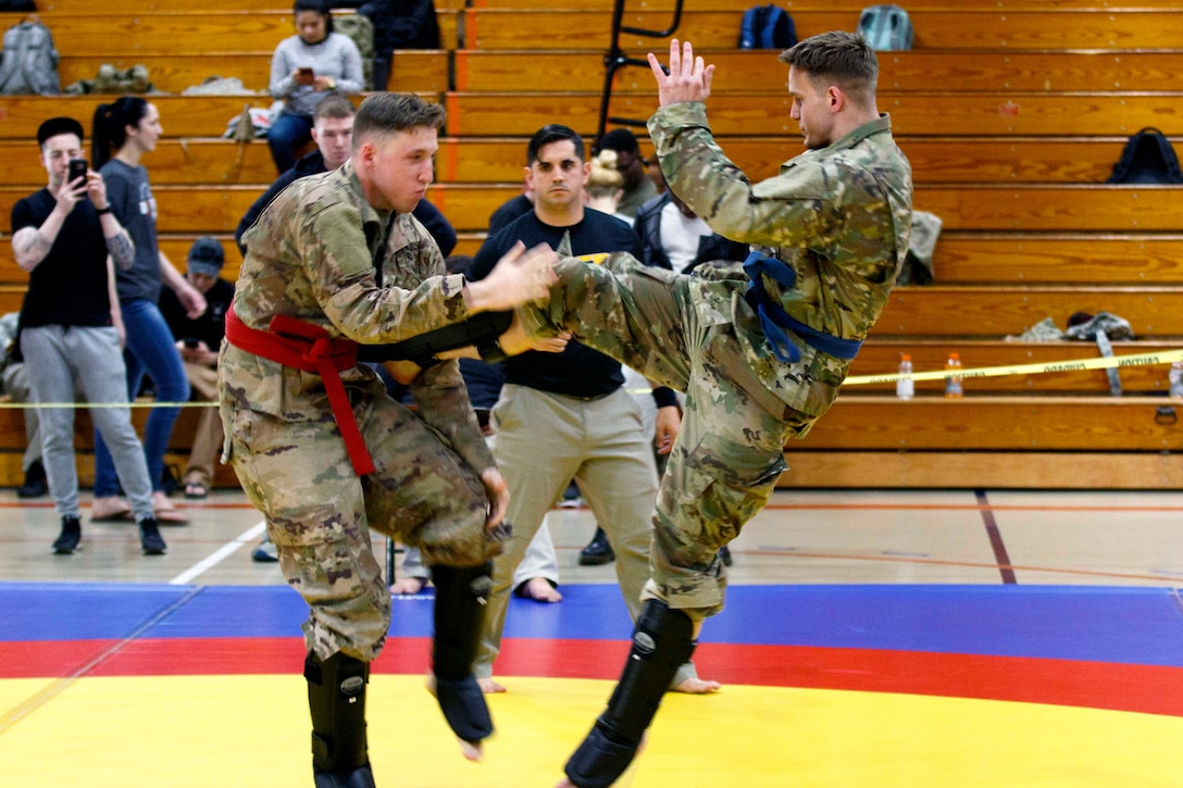 A soldier blocks his opponents flying kick.