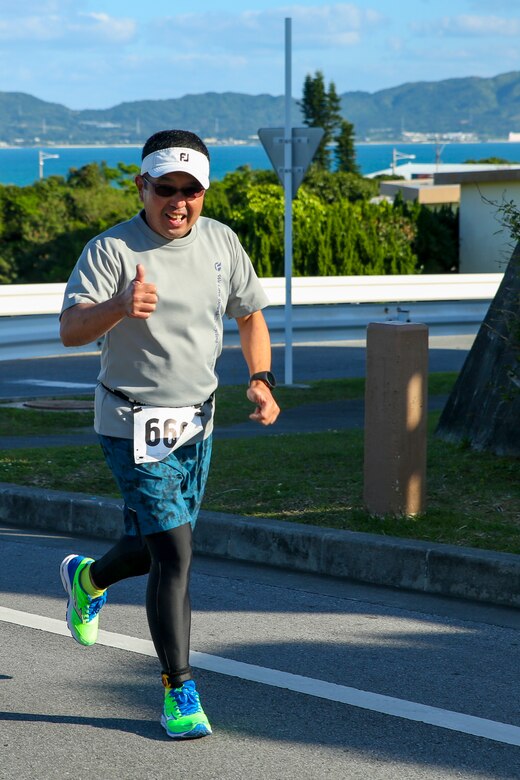 A runner from the local community smiles as he runs the first loop of the 10-kilometer route during the Lord of Tegan Run March 11 aboard Camp Courtney, Okinawa, Japan. The annual race invited the local community on base for a friendly fun-run. Approximately 50 athletes competed this year. (U.S. Marine Corps photo by Pfc. Nicole Rogge)