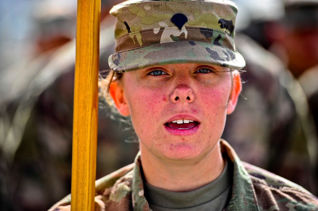 Spc. Sarah Seqida, sings the Army song along with other soldiers during the change of responsibility ceremony for the 1st Battalion, 7th Air Defense Artillery at Al Dhafra Air Base, United Arab Emirates, March 11, 2018. Seqida, is a native of Pittsburgh, Pennsylvania. 

 (U.S. Air Force photo by Tech. Sgt. Anthony Nelson Jr)
