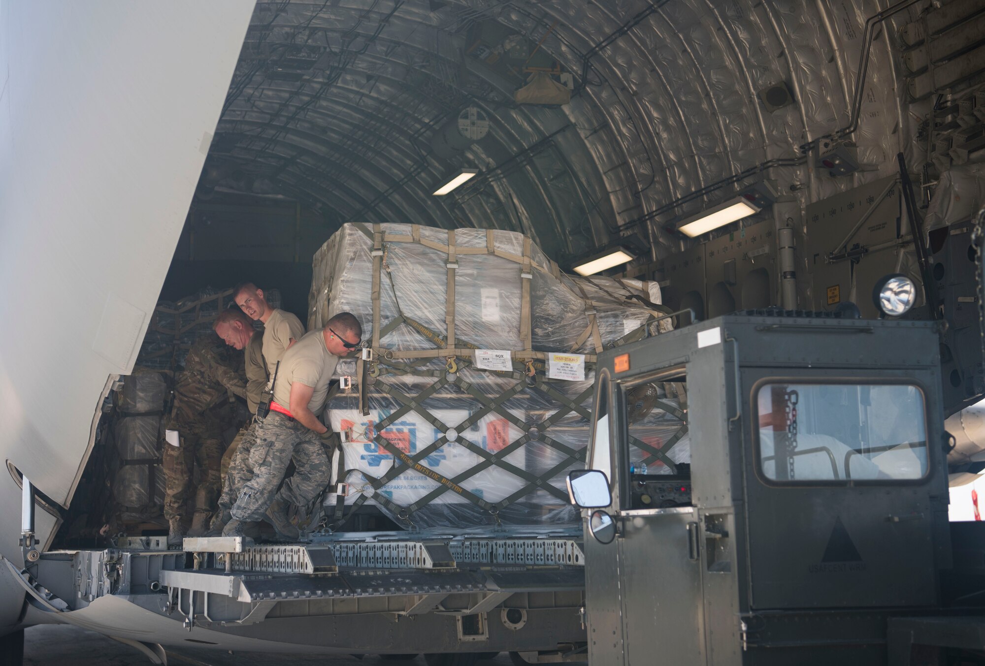 Members of the 332nd Expeditionary Logistics Readiness Squadron upload pallets of supplies from a C-17 Globemaster III at an undisclosed location in Southwest Asia March 7, 2018.