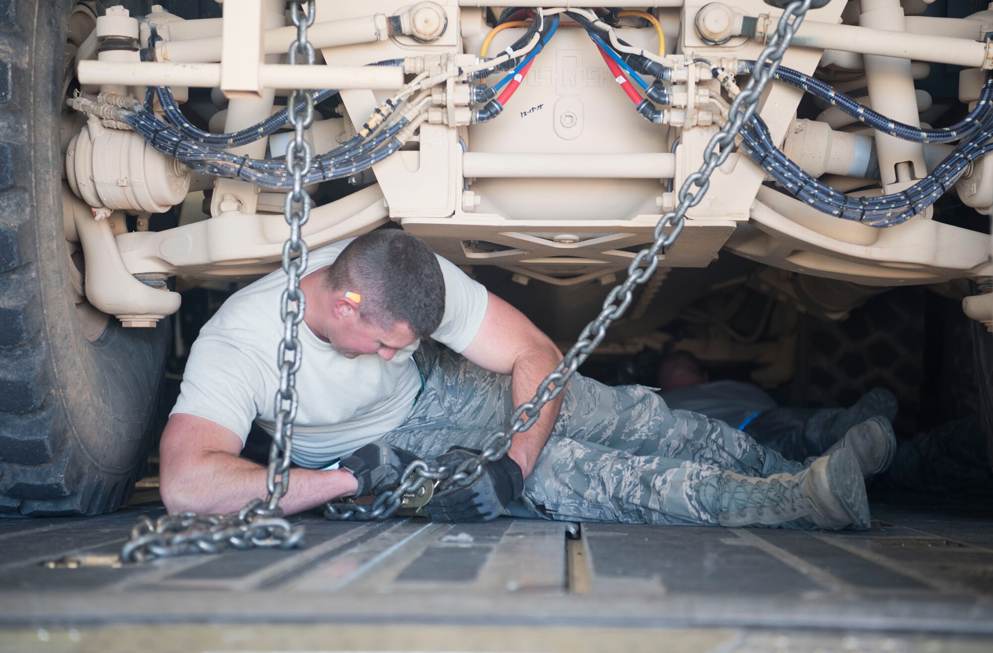 Tech. Sgt. Josiah Bourke, 332nd Expeditionary Logistics Readiness Squadron air transportation specialist, secures a mine-resistant ambush protected vehicle with chains for transportation onto a C-17 Globemaster III at an undisclosed location in Southwest Asia March 7, 2018.