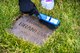 A Kaiserslautern Military Community member cleans a gravestone at the American Kindergraves in Kaiserslautern, Germany, March 10, 2018. From 1952 to 1971, 451 American infants lost their lives at birth or shortly after birth at local hospitals. Families buried the remains of those children in a cemetery near the U.S. Army Daenner Kaserne and named the memorial Kindergraves. (U.S. Air Force photo by Senior Airman Devin Boyer)