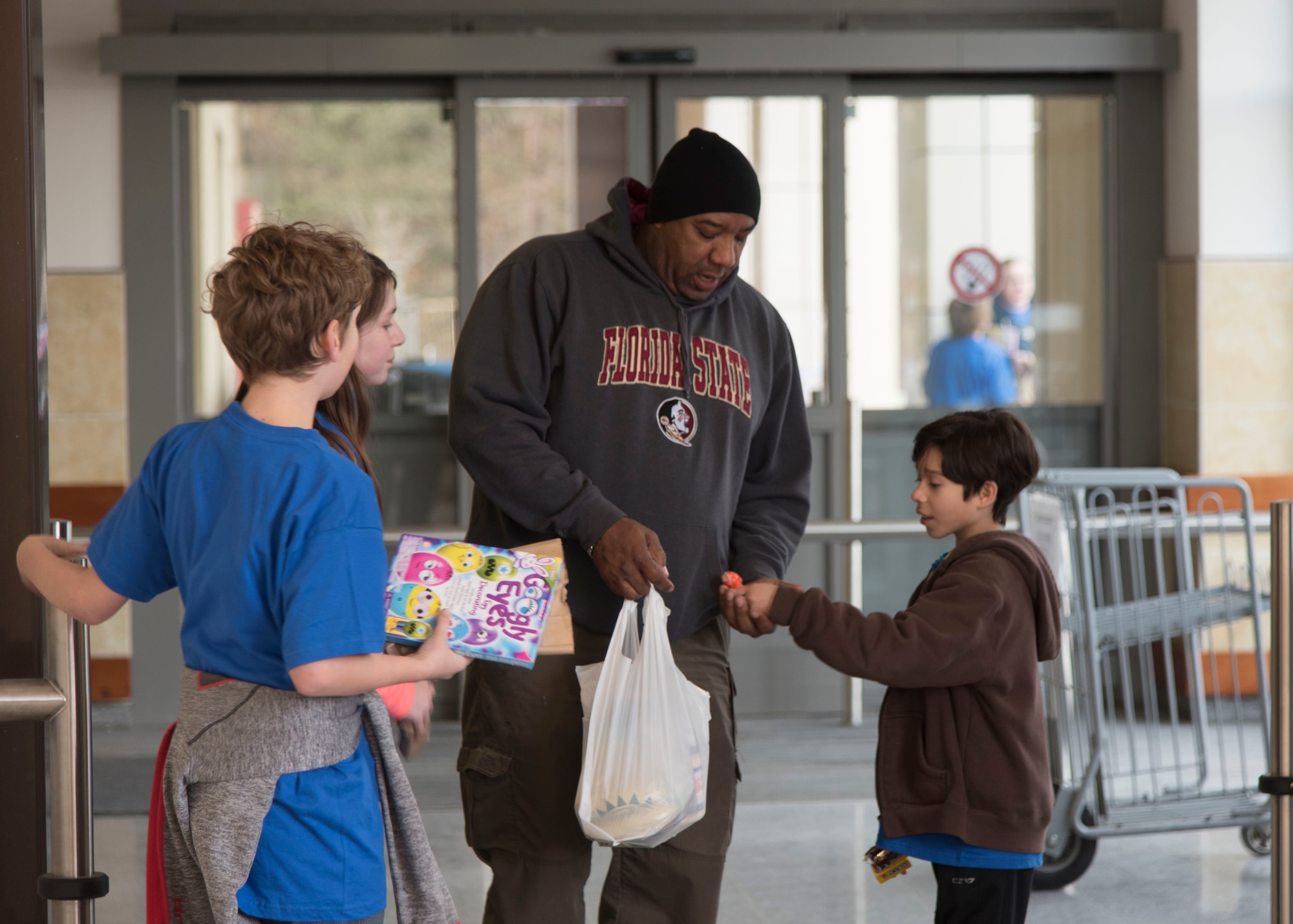 Members of Ramstein’s Boys and Girls Club of America Torch Club give candy to a commissary customer in efforts to give back on Ramstein Air Base, Germany, March 7, 2018. Seeds of Kindness, the Torch Club’s national project, was an opportunity for members of the Torch Club to give to people in the community. (U.S. Air Force photo by Airman 1st Class Kaylea Berry)