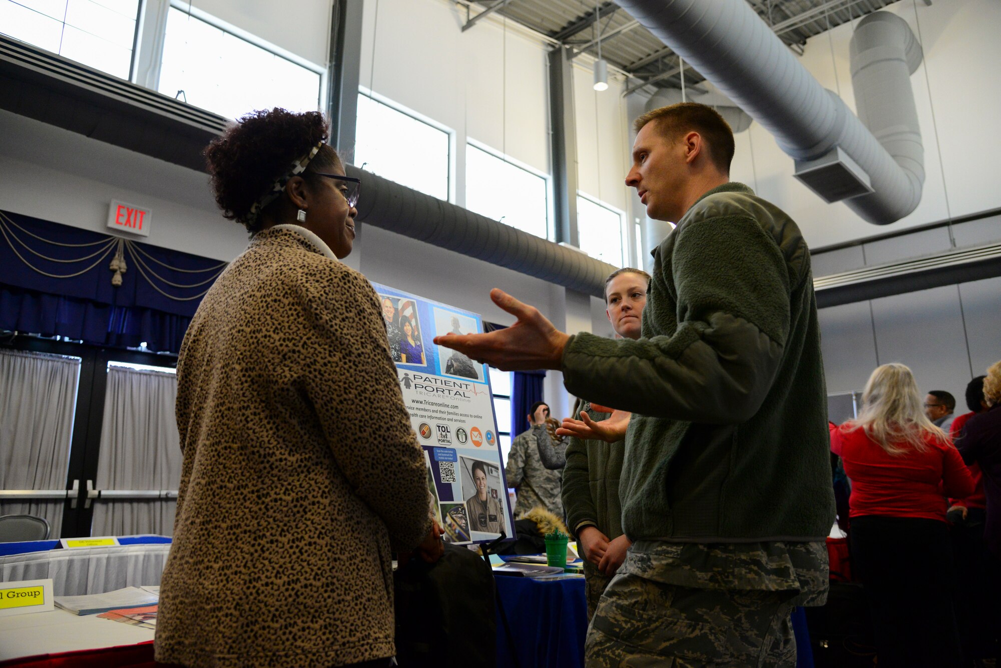 Trina Brown-Hicks, Humana, speaks with Maj. Nick Freese, 436th Medical Group practice manager, and Airman 1st Class Morgan Stanfield, 436th Medical Group medical records technician, during the second annual Spouse Symposium March 7, 2018, at Dover Air Force Base, Del. Representatives of the 436th MDG, Military One Source, the USO and several other base organizations set up booths at the career information fair during the event to help inform spouses of the support provided by the installation. (U.S. Air Force photo by Staff Sgt. Aaron J. Jenne)
