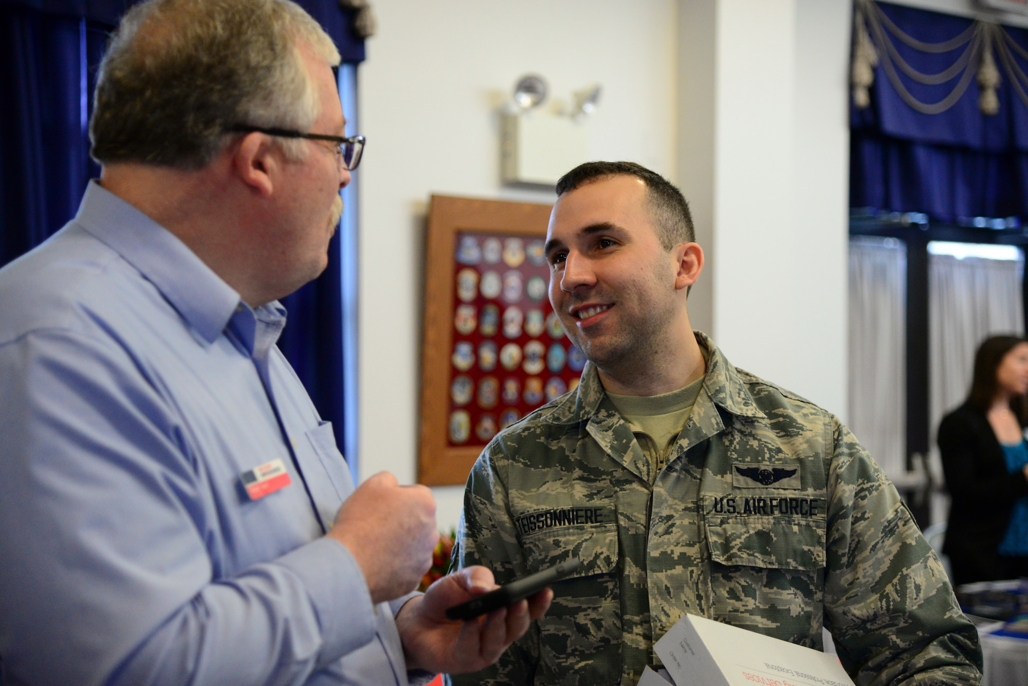 Roger Saul, Military One Source, speaks with Airman 1st Class Jonathan Teissonniere, 9th Airlift Squadron loadmaster, about several job opportunities for his spouse during the career information fair segment of the second annual Spouse Symposium March 7, 2018, at Dover Air Force Base, Del. Spouses of active duty and reserve Airmen were invited to attend the free event. (U.S. Air Force photo by Staff Sgt. Aaron J. Jenne)