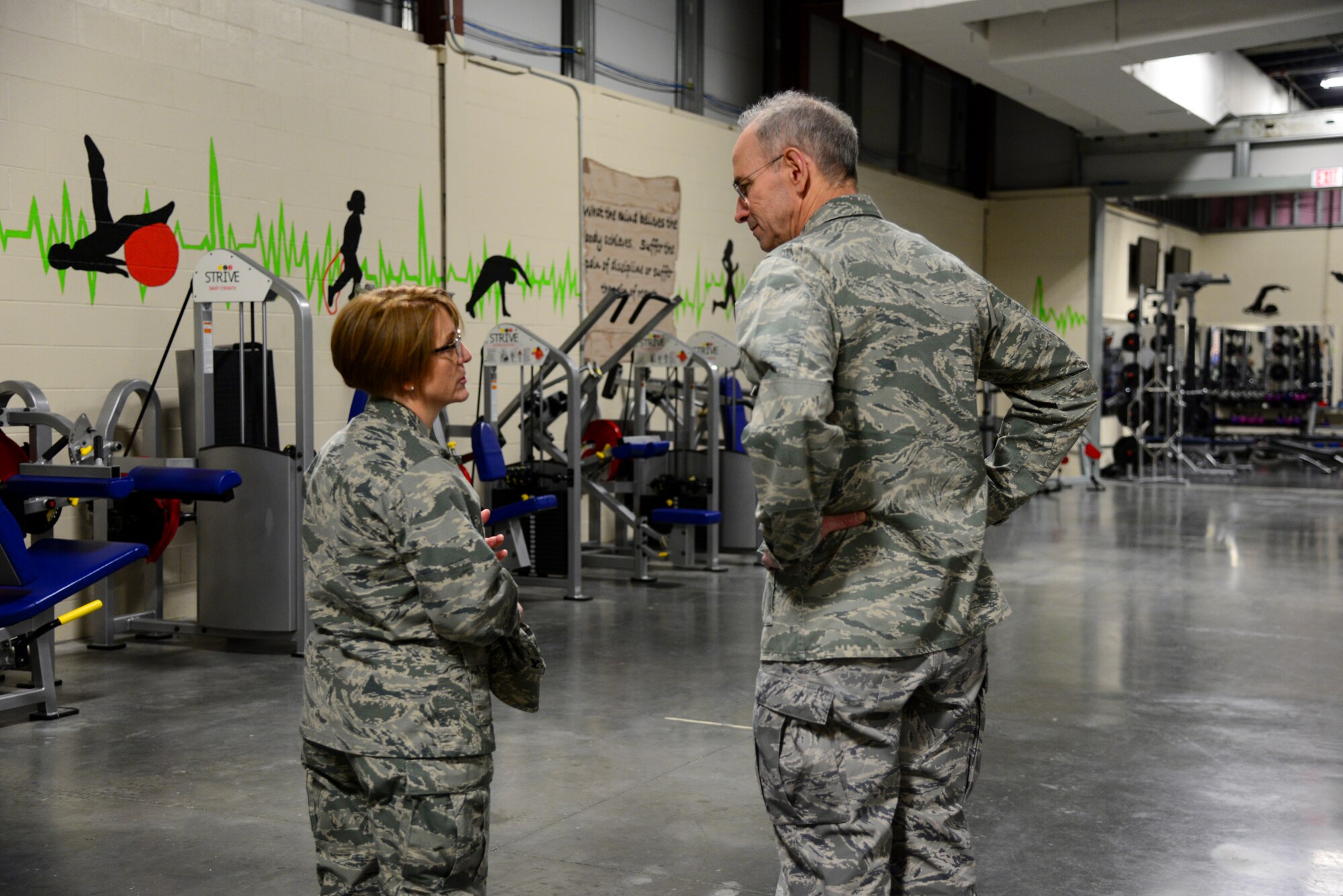 Col. Dawn Lancaster, Air Force Mortuary Affairs Operations commander, speaks with Air Force Surgeon General Lt. Gen. (Dr.) Mark Ediger in the AFMAO fitness facility during an orientation March 9, 2018, at Dover Air Force Base, Del. Lancaster explained the importance of Comprehensive Airman Fitness, how it relates to the Airmen assigned to AFMAO and how their resilience programs encourage physical, mental, social and spiritual strength. (U.S. Air Force photo by Staff Sgt. Aaron J. Jenne)