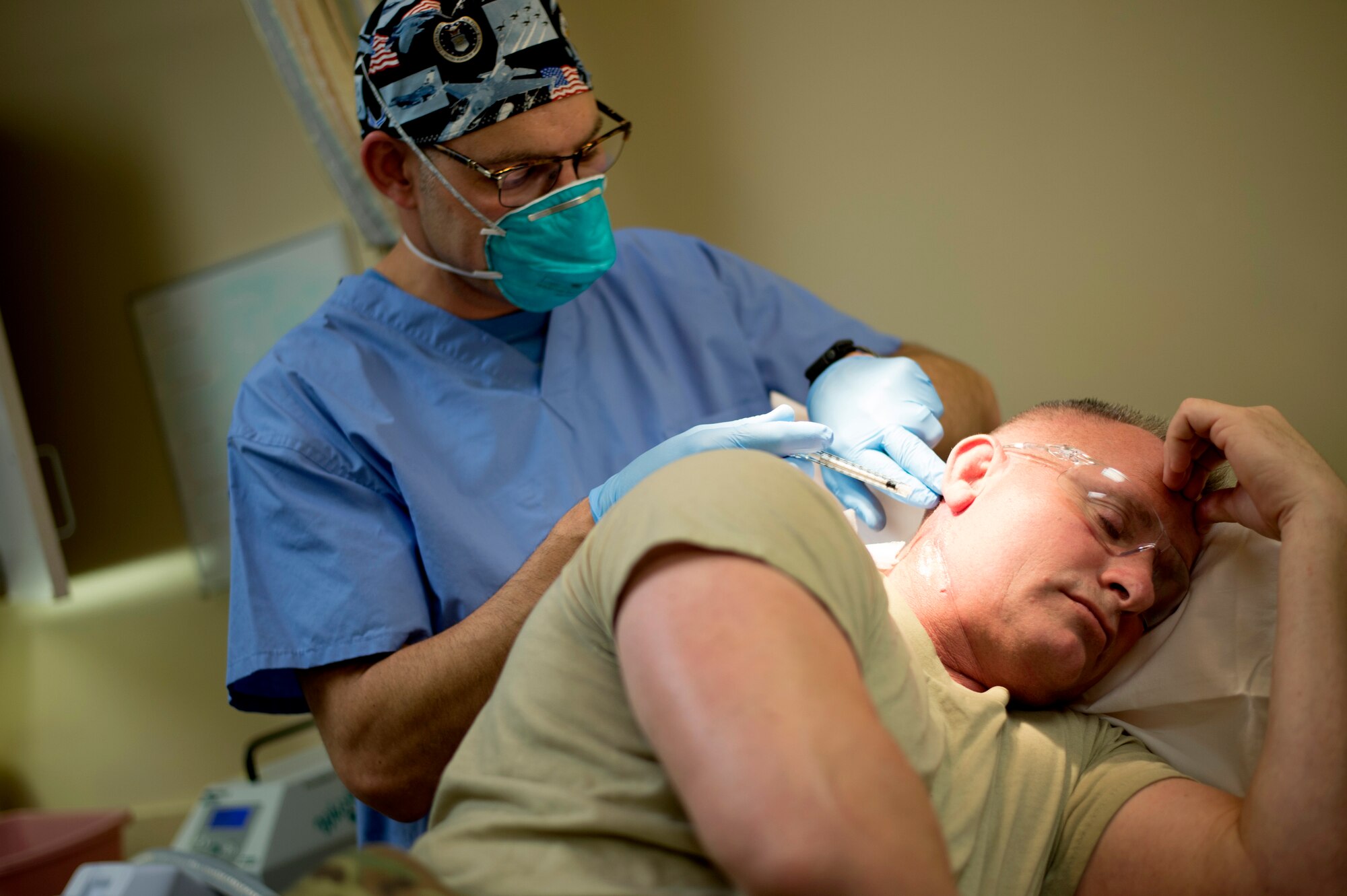 Maj. (Dr.) Thomas Beachkofsky, dermatology element leader assigned to the 6th Medical Group, puts a liquid medication on a dermatology patient after a laser treatment at MacDill Air Force Base, Fla., March 9, 2018.