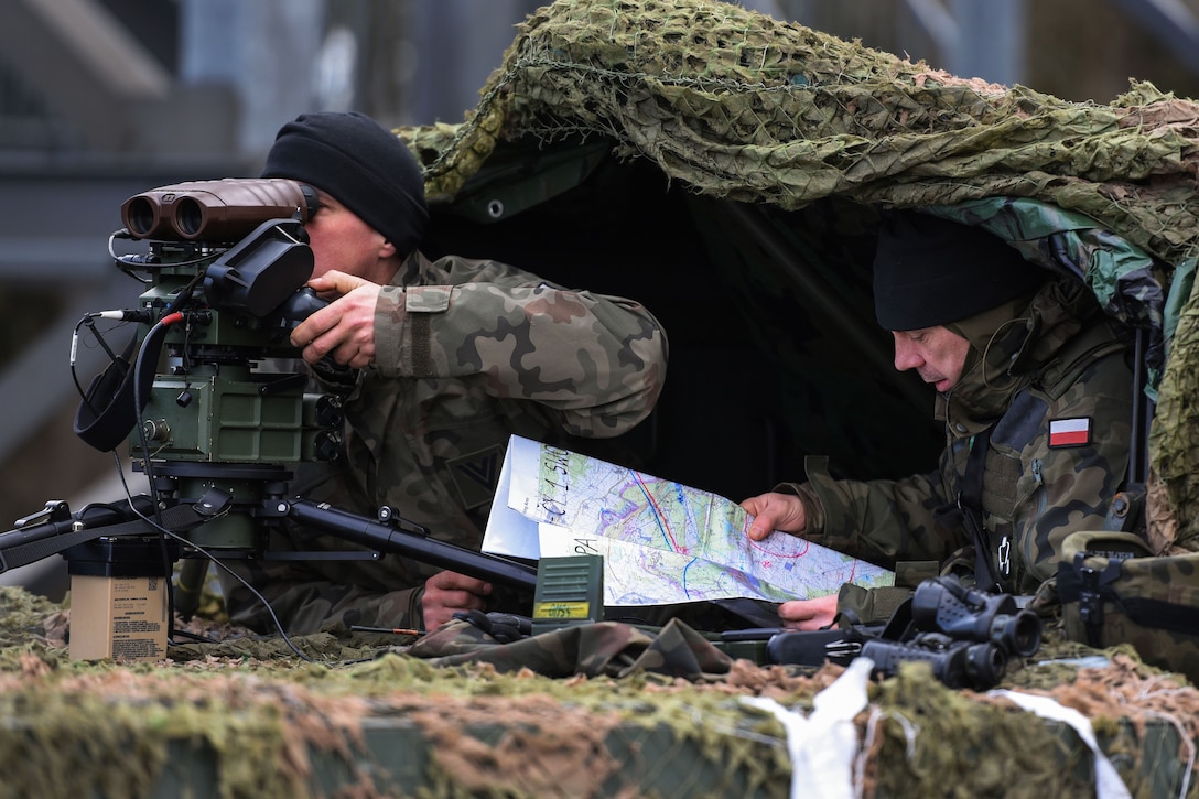 A Polish soldier reviews a terrain map.