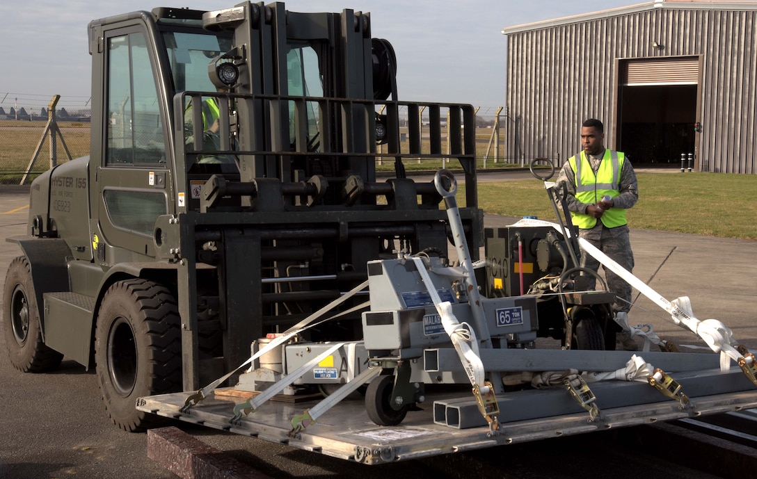 U.S. Air Force Senior Airman Kelvin Mason, 100th Logistics Readiness Squadron traffic management officer, supervises the moving of cargo at RAF Mildenhall, England, March 9, 2018. The cargo was part of a cargo deployment function scheduled to go to Camp Lemonier, Djibouti. (U.S. Air Force photo by Airman 1st Class Benjamin Cooper)