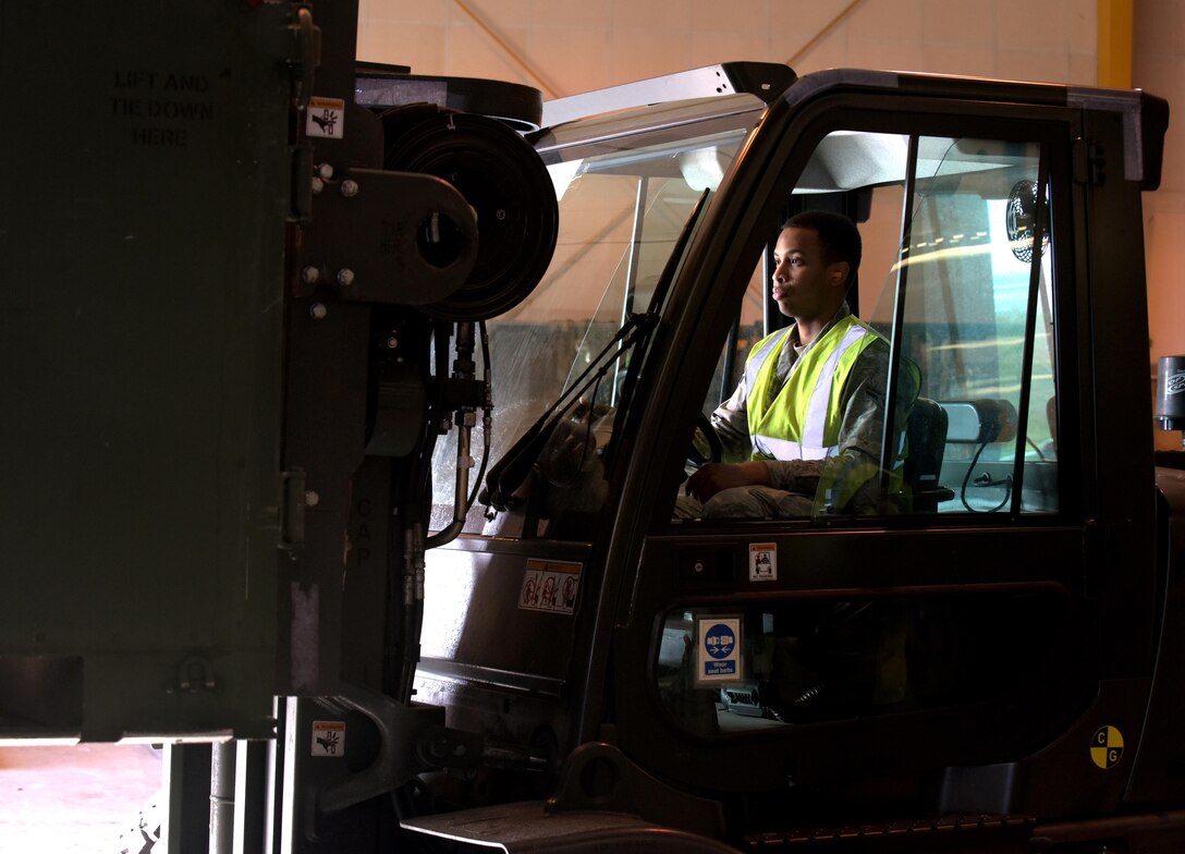 U.S. Air Force Airman 1st Class Daniel Johnson, 100th Logistics Readiness Squadron traffic management officer, lifts an internal-stability unit off the scale at RAF Mildenhall, England, March 9, 2018. All cargo must be weighed prior to departure so it can be positioned correctly inside the aircraft. (U.S. Air Force photo by Airman 1st Class Benjamin Cooper)
