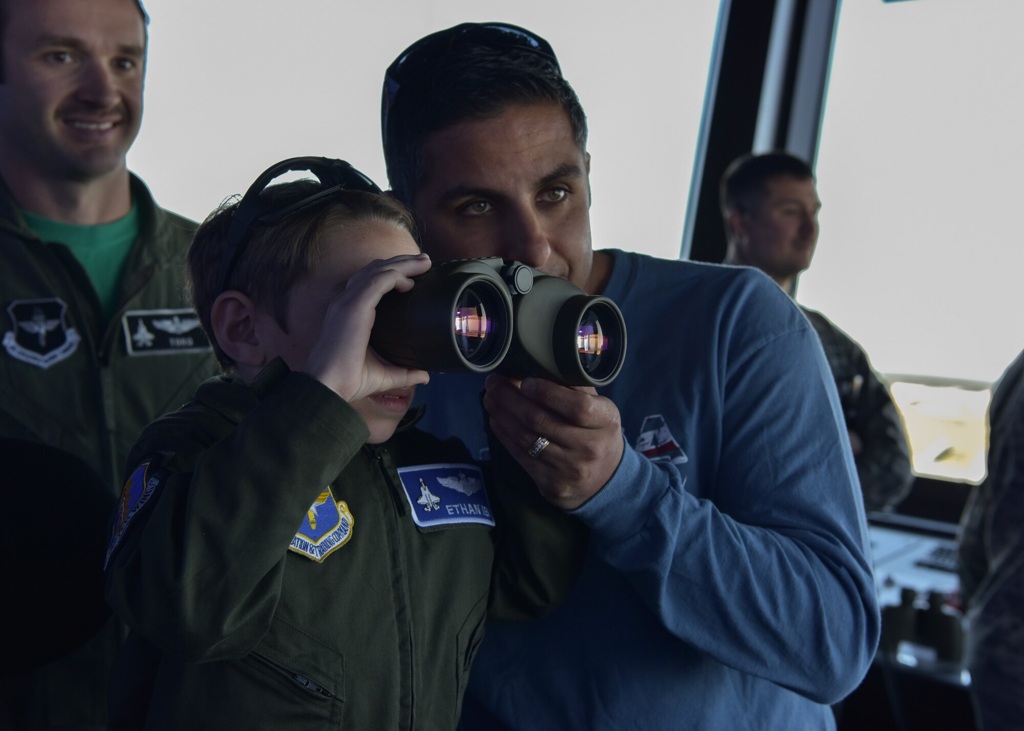 Ethan Ibi, pilot for a day, overlooks the base with binoculars with his dad March 9, 2018, at Eglin Air Force Base, Fla. The 33rd Fighter Wing hosted Ethan Ibi and his family for the "Pilot for a day" program. (U.S. Air Force photo by Airman 1st Class Emily Smallwood)
