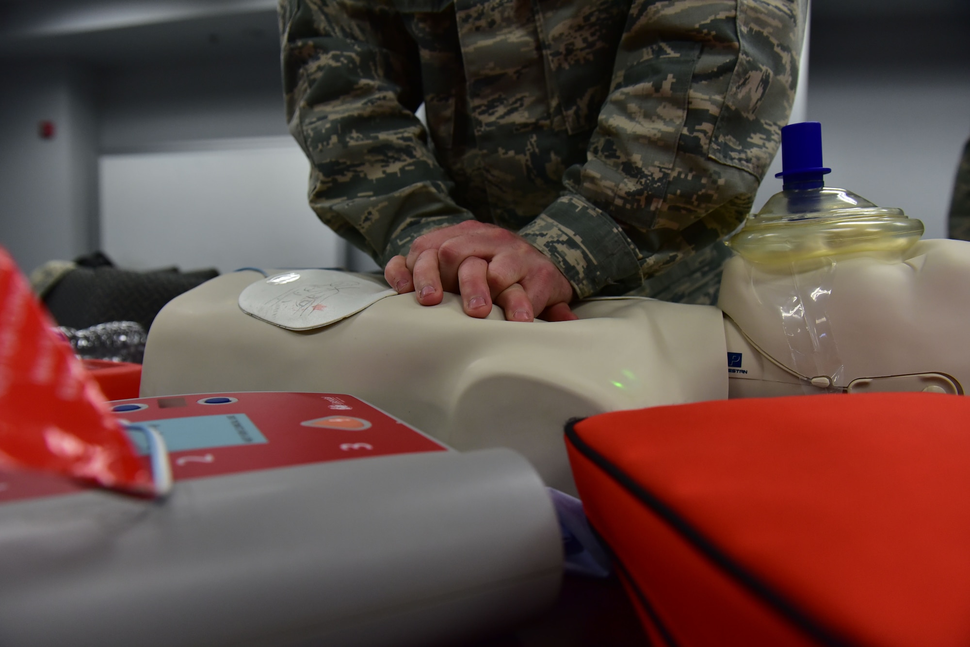 Hands press down on a CPR dummy