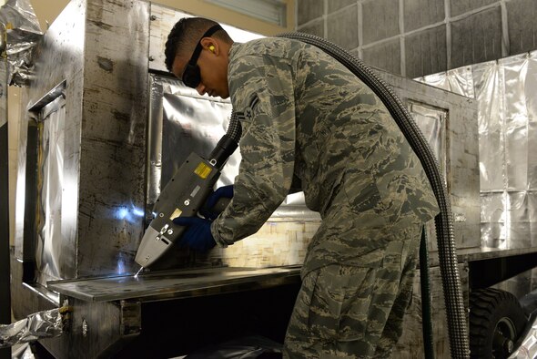 Airman 1st Class Levi Gordon, 60th Maintenance Squadron aircraft structural maintenance, uses a Clean Laser 1000 to remove paint from a sheet of metal March 7 at Travis Air Force Base, California. The 1000-watt laser can remove paint and corrosion. It reduces the waste created from sanding paint by 90 percent Travis was chosen as one of two bases to test the capabilities of the laser. (U.S. Air Force photos by Staff Sgt. Amber Carter)