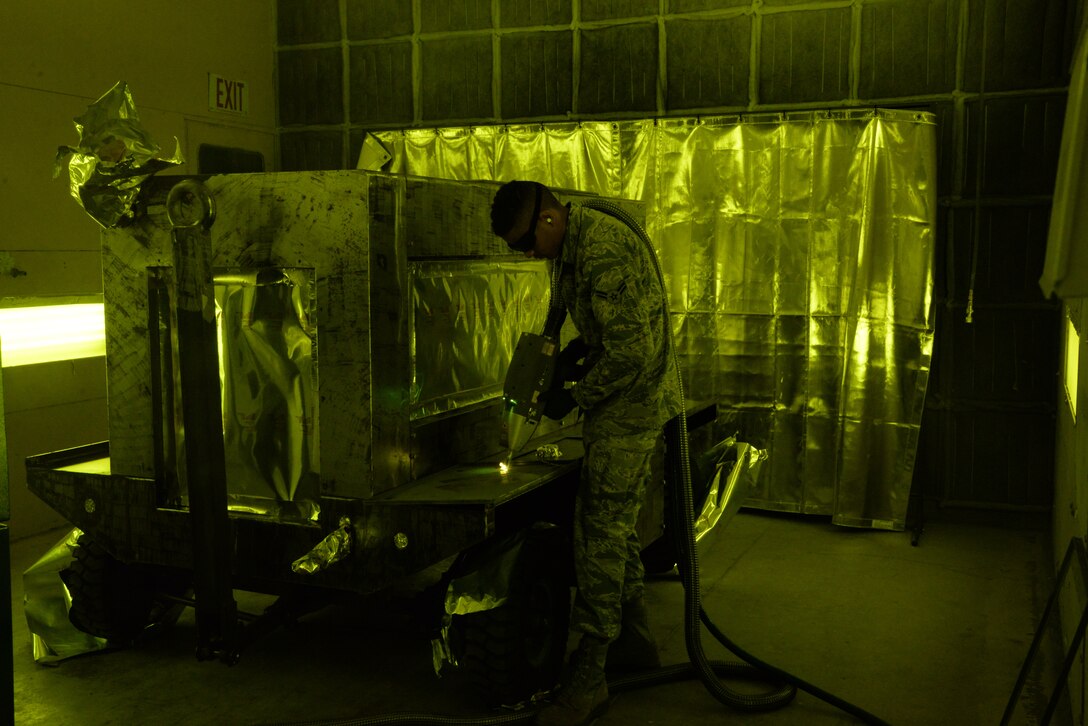 Airman 1st Class Levi Gordon, 60th Maintenance Squadron aircraft structural maintenance, uses a Clean Laser 1000 to remove paint from a sheet of metal March 7 at Travis Air Force Base, California. The 1000-watt laser can remove paint and corrosion. It reduces the waste created from sanding paint by 90 percent Travis was chosen as one of two bases to test the capabilities of the laser. (U.S. Air Force photos by Staff Sgt. Amber Carter)