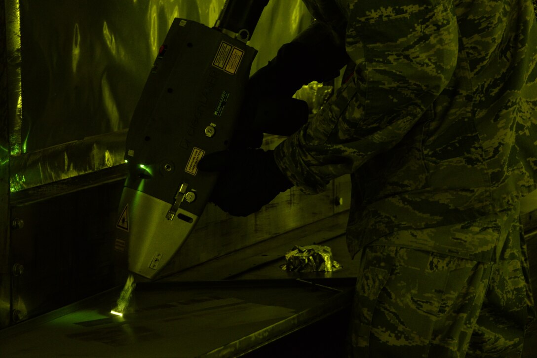Airman 1st Class Levi Gordon, 60th Maintenance Squadron aircraft structural maintenance, uses a Clean Laser 1000 to remove paint from a sheet of metal March 7 at Travis Air Force Base, California. The 1000-watt laser can remove paint and corrosion. It reduces the waste created from sanding paint by 90 percent Travis was chosen as one of two bases to test the capabilities of the laser. (U.S. Air Force photos by Staff Sgt. Amber Carter)
