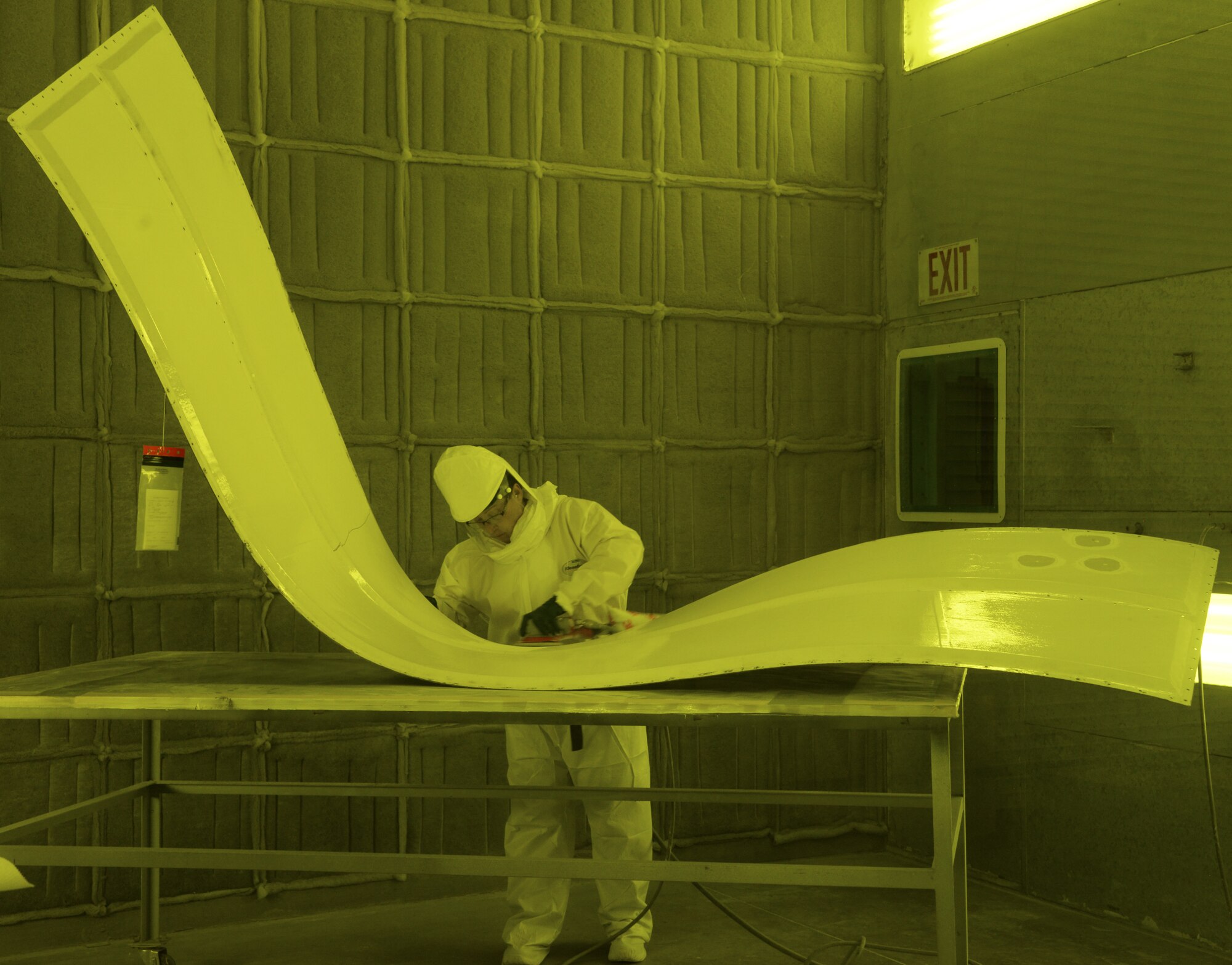 Kathy Fruits, 60th Maintenance Squadron aircraft structural maintenance, uses a sander to remove paint March 7 at Travis Air Force Base, Calif. The suit is completely air sealed and hooked up to oxygen in order to protect her from harmful paint chemicals that are released during the sanding process. The suit is not needed while using the Clean Laser due to the reduction of sawdust and airborn debris. (U.S. Air Force photo by Staff Sgt. Amber Carter)