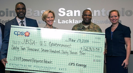 Garrick Williams (left), JBSA Energy Solutions director with CPS Energy, presents (from left) Brig. Gen. Heather Pringle (right), 502nd Air Base Wing and Joint Base San Antonio commander, Col. Lee Flemming, 502nd ABW and JBSA vice commander, and Brenda Roesch, 502nd Civil Engineer Squadron director, a rebate check for $62,763.04 at the 502nd ABW headquarters at JBSA-Fort Sam Houston March 13.