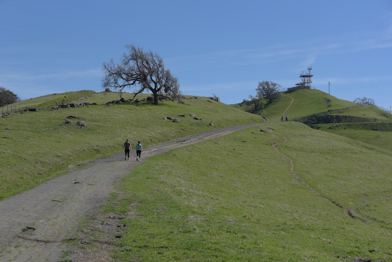 Tech. Sgt. Nikki Webb (Left), 60th Air Mobility Wing, hikes down a hill at Pena Adobe Regional Park in Vacaville, Calif., with her cousin, Senior Master Sgt. Jenny Hendry (Right), 60th Aeromedical Squadron, March 11, 2018. Hendry joined Webb on a 10-mile hike as she prepares for the Bataan Memorial Death March on March 25. (U.S. Air Force photo/Tech. Sgt. James Hodgman)