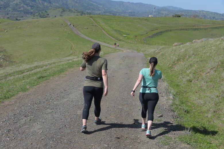 Tech. Sgt. Nikki Webb (Left), 60th Air Mobility Wing, hikes down a hill at Pena Adobe Regional Park in Vacaville, Calif., with her cousin, Senior Master Sgt. Jenny Hendry (Right), 60th Aeromedical Squadron, March 11, 2018. Hendry joined Webb on a 10-mile hike as she prepares for the Bataan Memorial Death March on March 25. (U.S. Air Force photo/Tech. Sgt. James Hodgman)